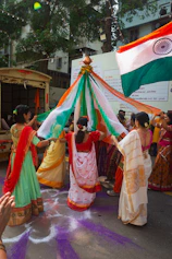 People in traditional indian attire celebrating with a flag