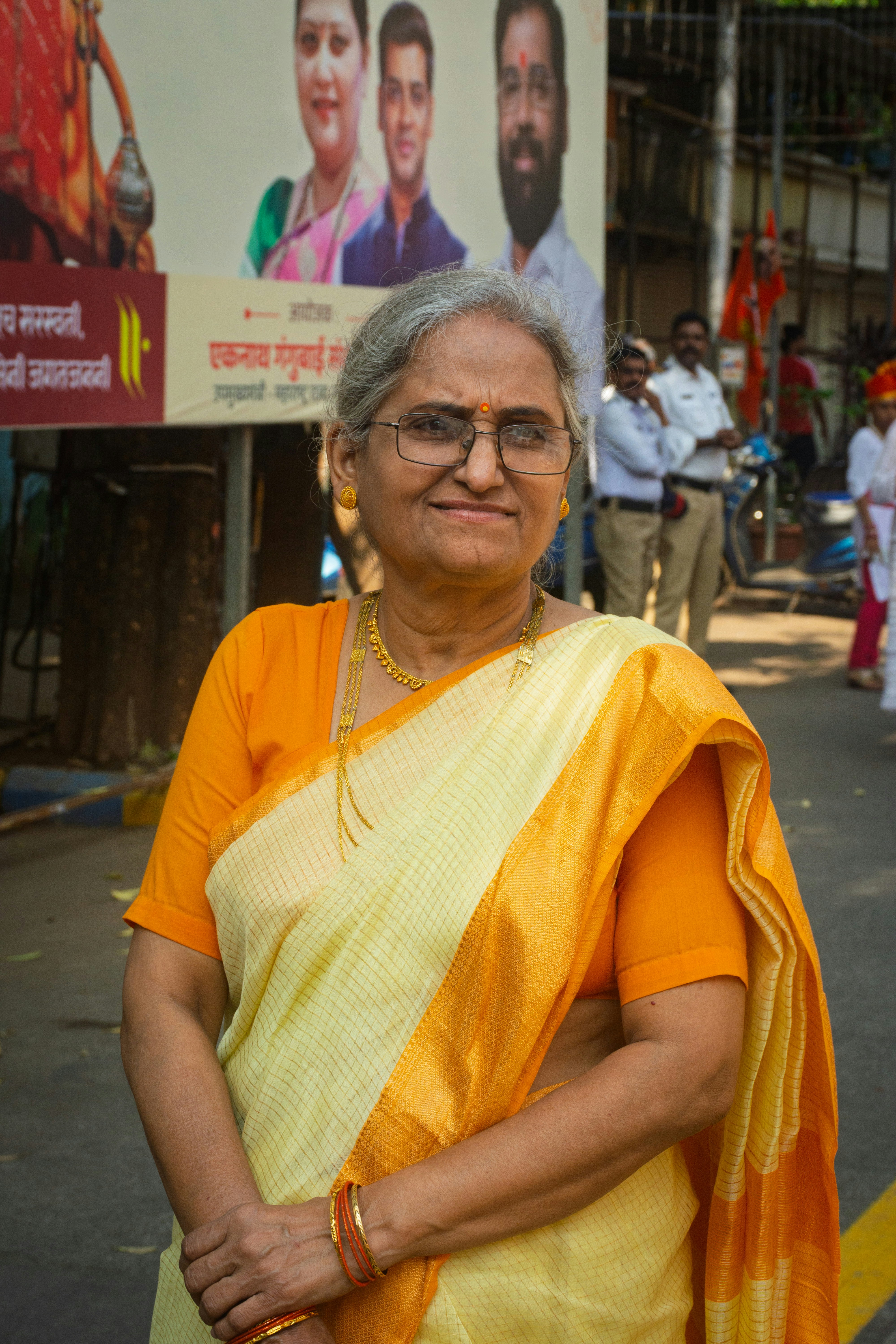 An elderly indian woman in a sari smiles