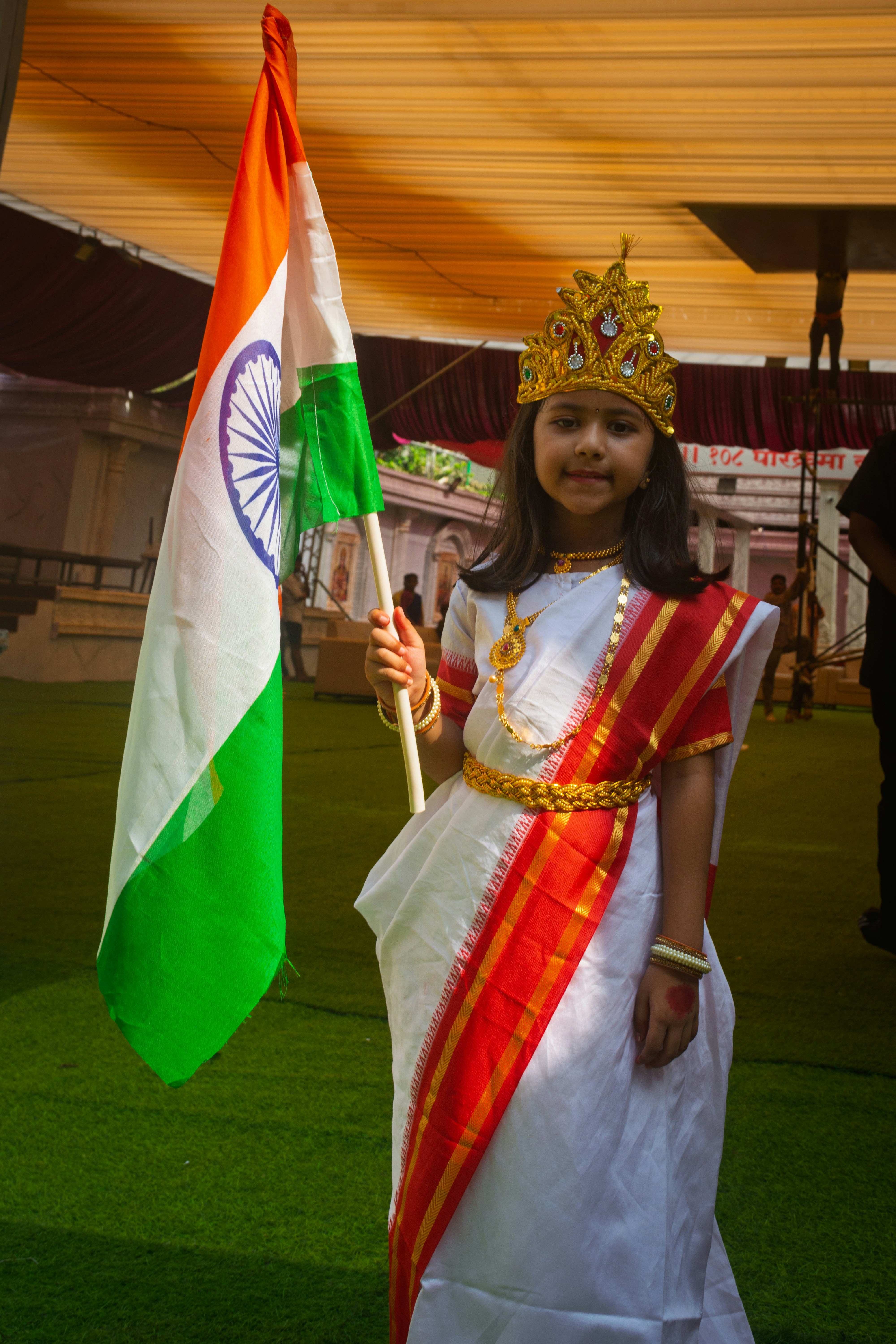 Young girl in traditional dress holds indian flag