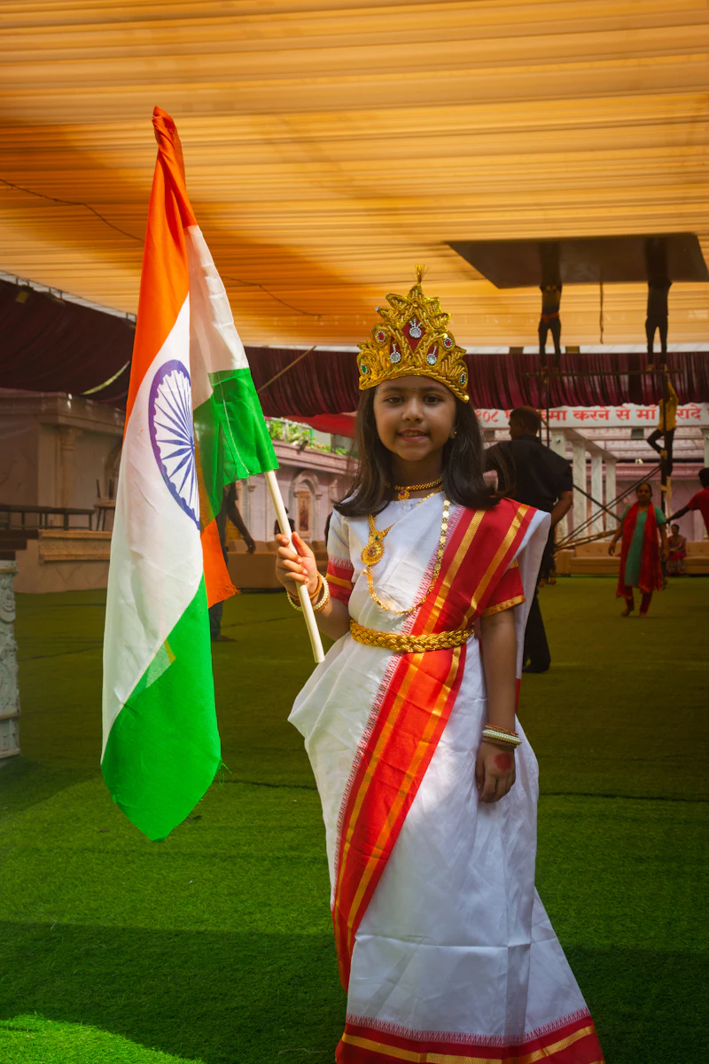 A young girl in traditional dress holding the Indian national flag