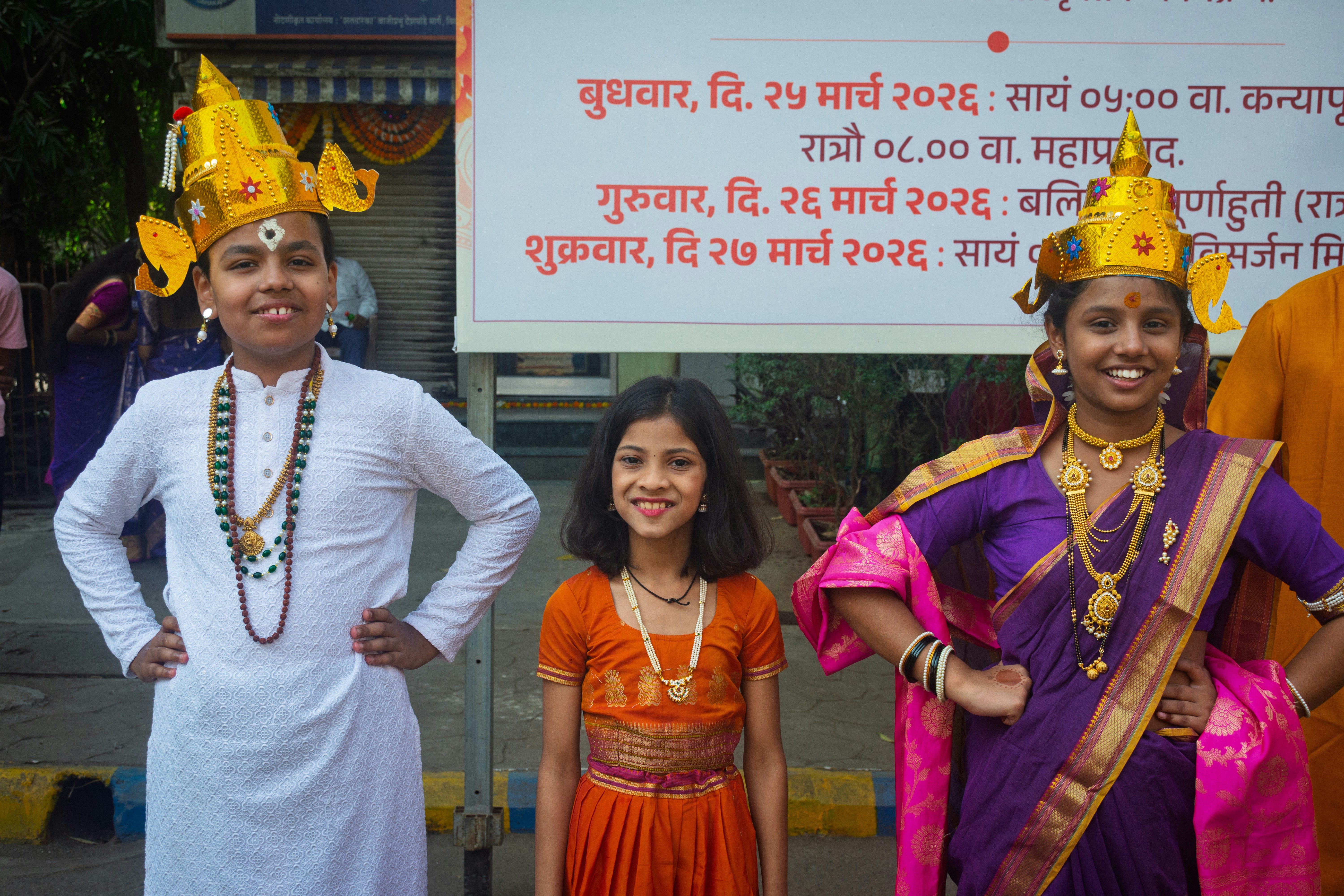Three children in traditional indian attire and headdresses.