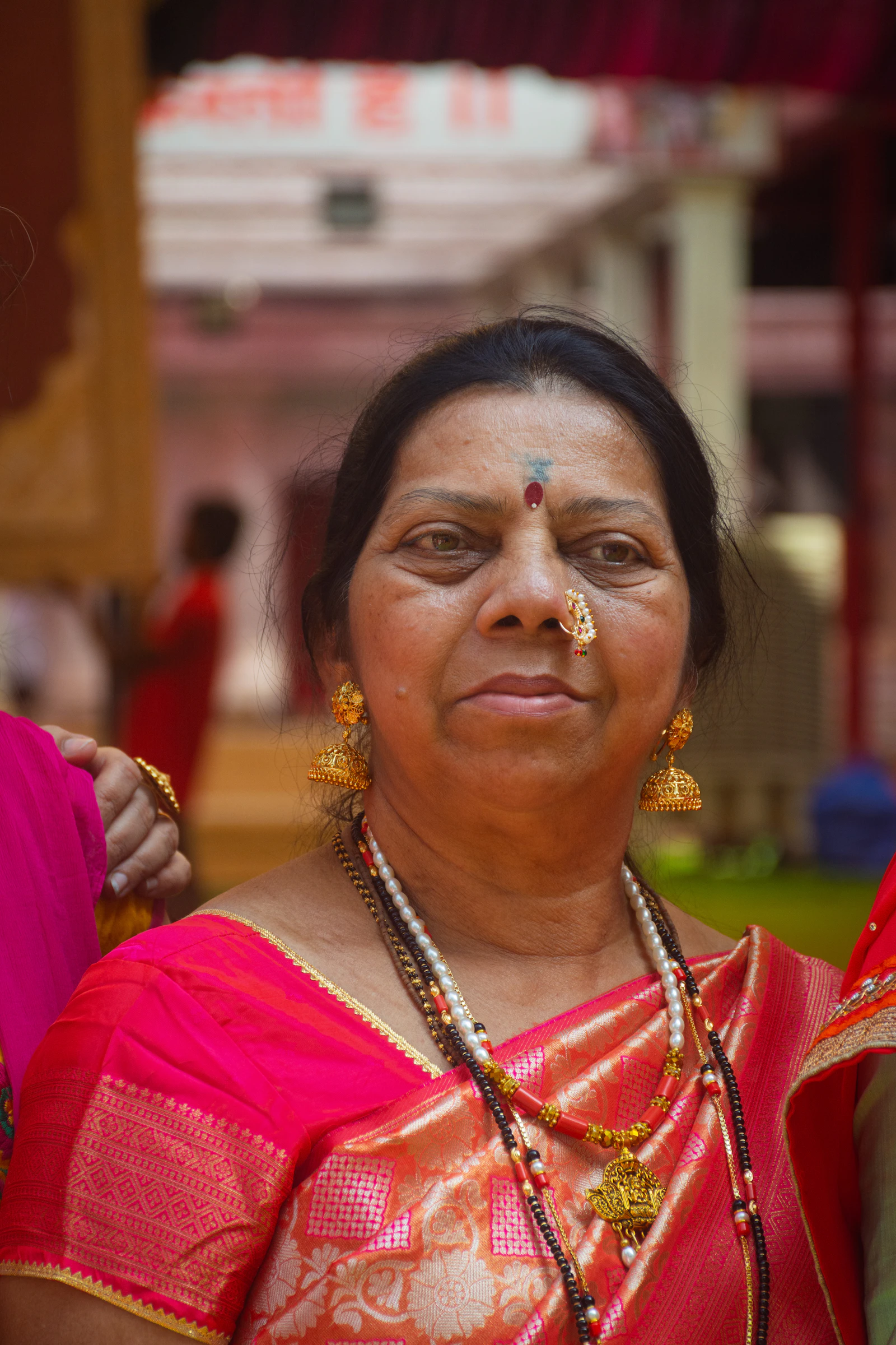 An elderly Indian woman wearing traditional jewellery