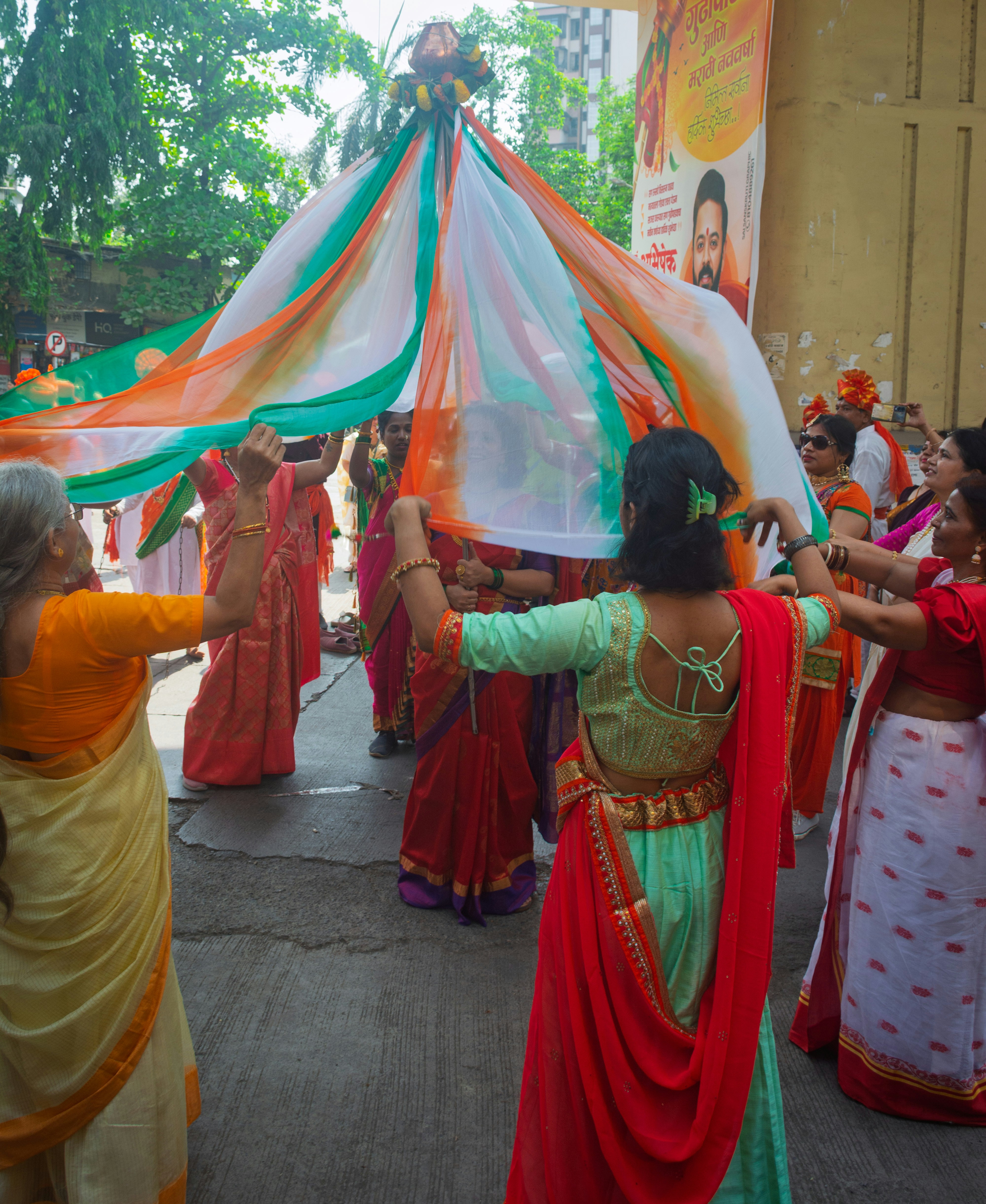People holding a colorful fabric in a celebration