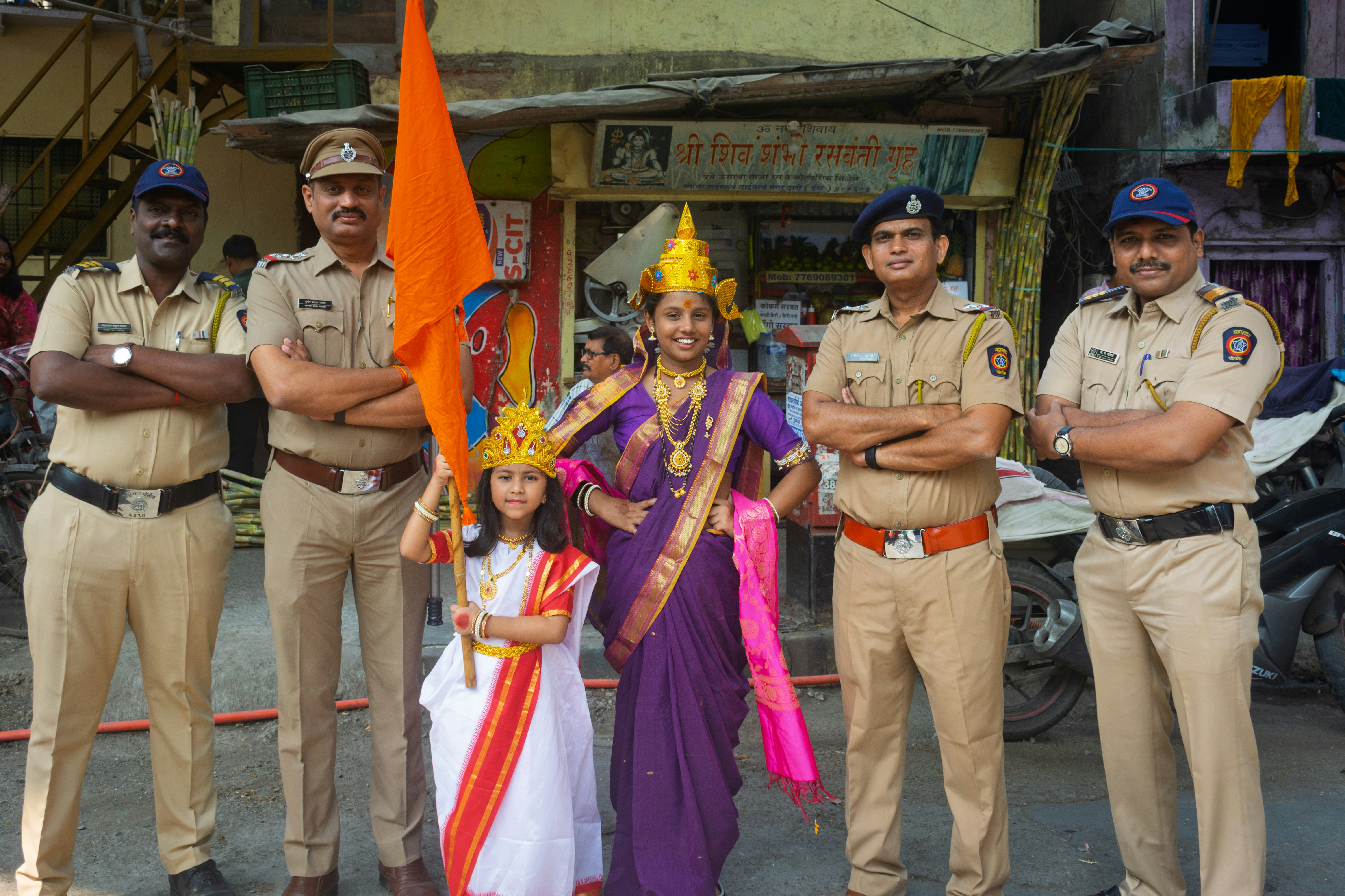 Police officers pose with people in traditional attire
