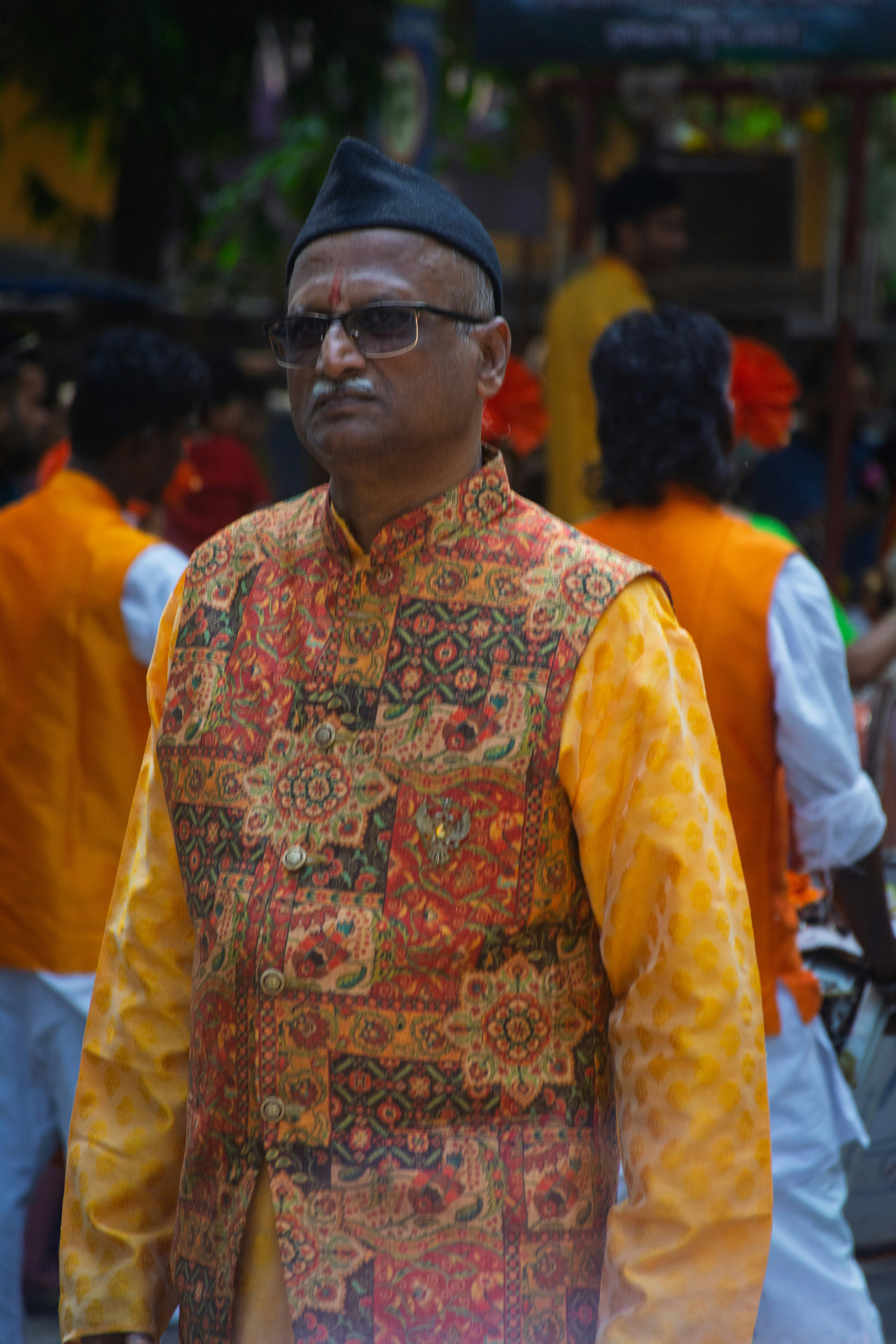 Pria dengan pakaian tradisional India dengan rompi warna-warni.