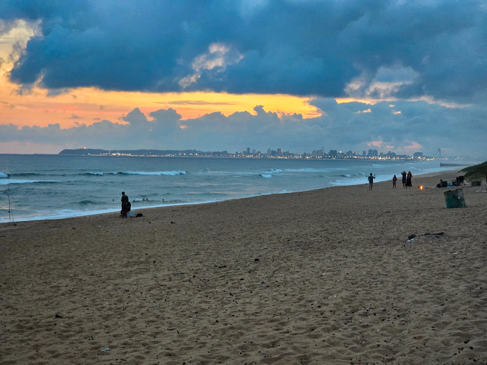 Beach with distant city skyline at sunset