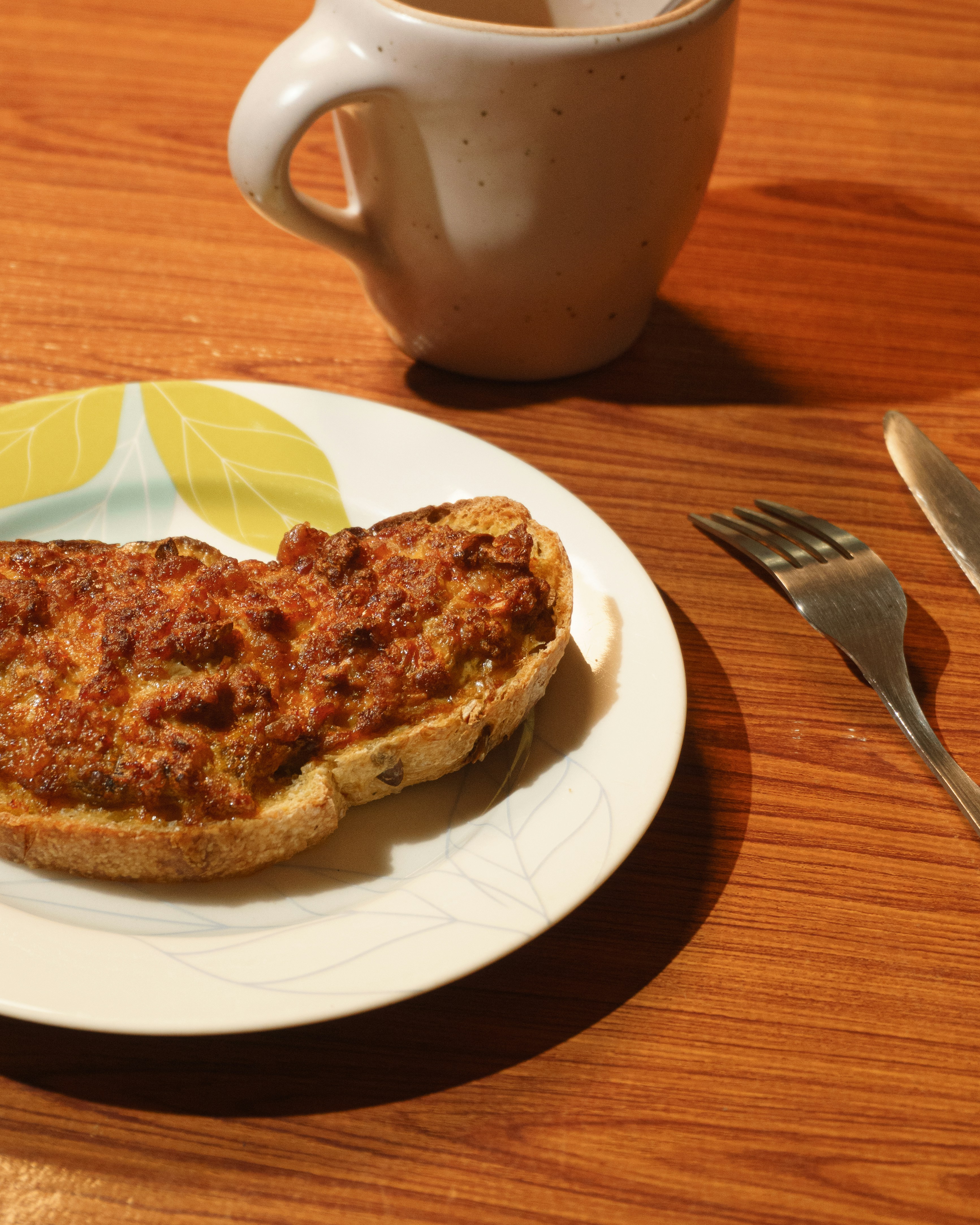 Geröstetes Brot mit Topping auf dem Teller neben der Tasse.