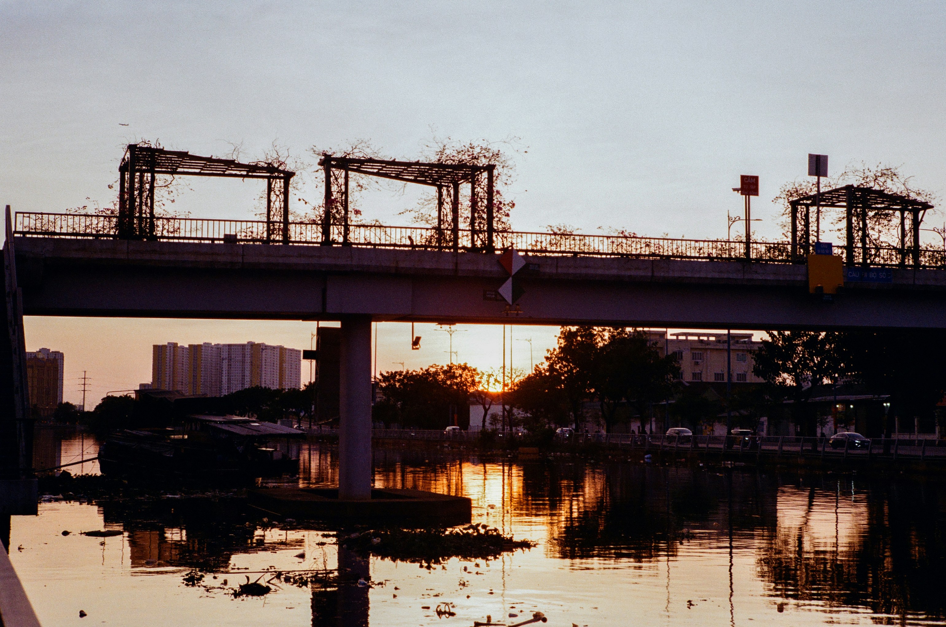 Bridge under construction at sunset over water