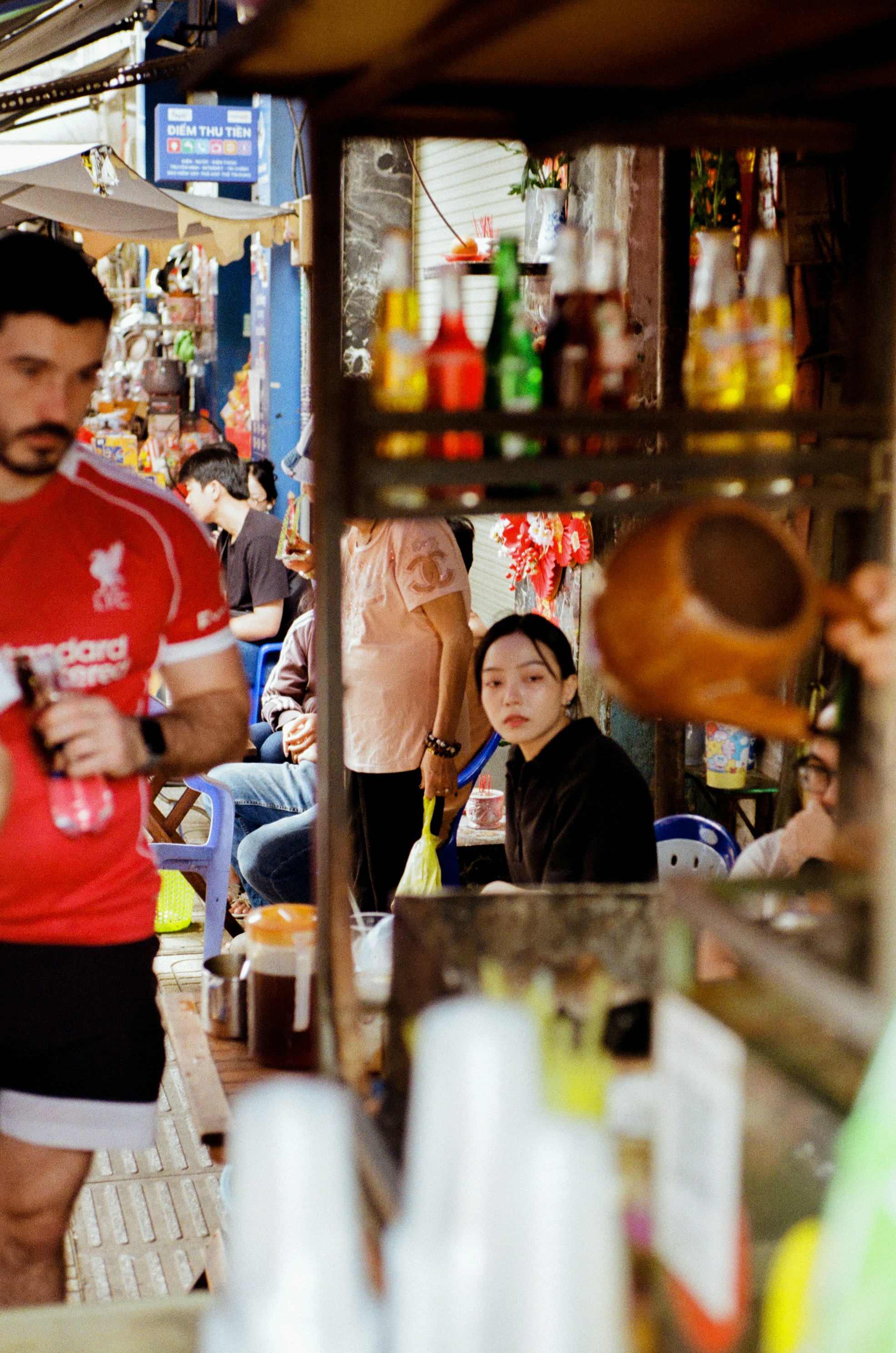 Young woman at a street food stall with bottles