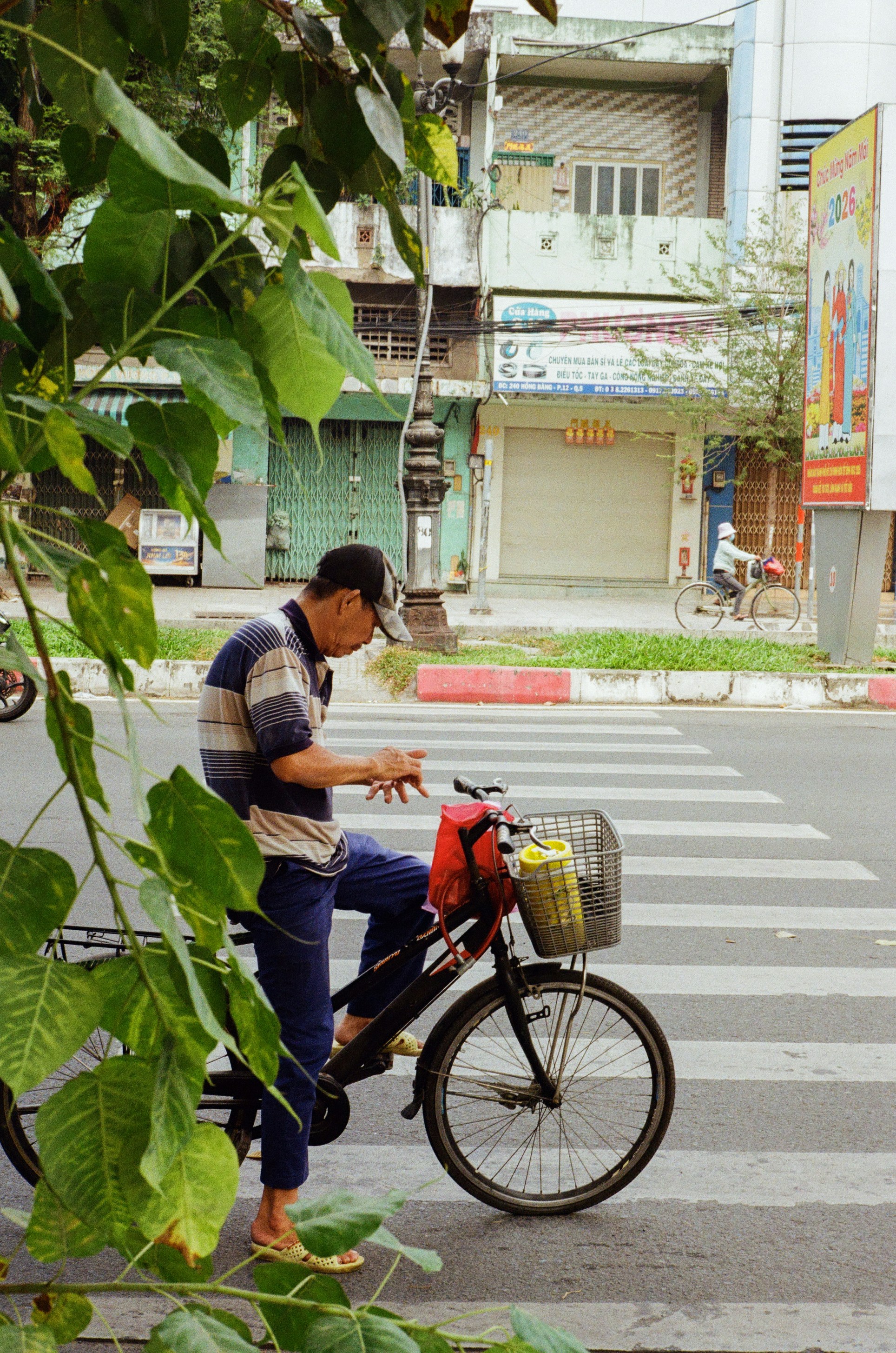 Man with bicycle on a street crossing.