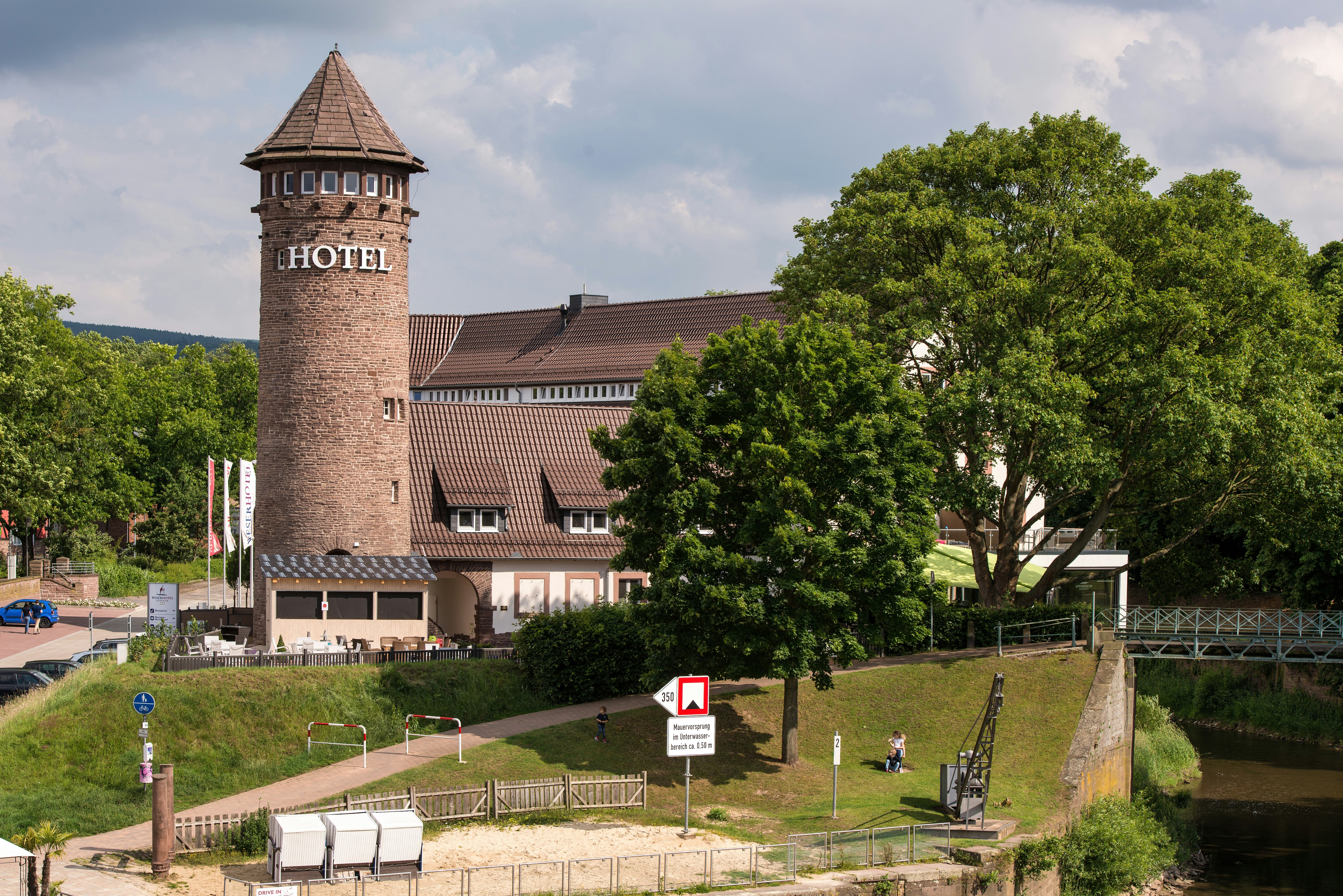 Historic tower building with "hotel" sign near water.