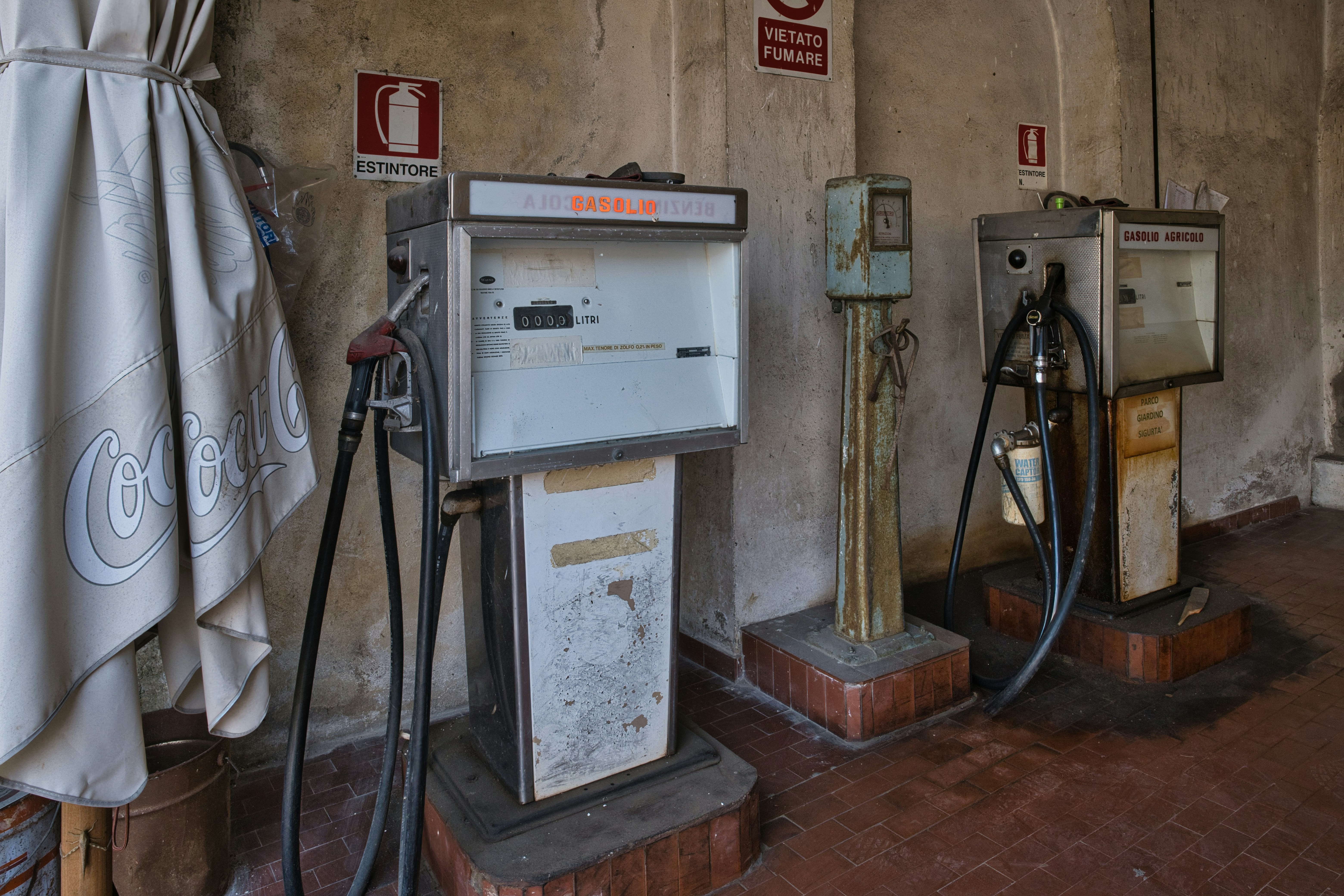 Two vintage gas pumps in a dusty building