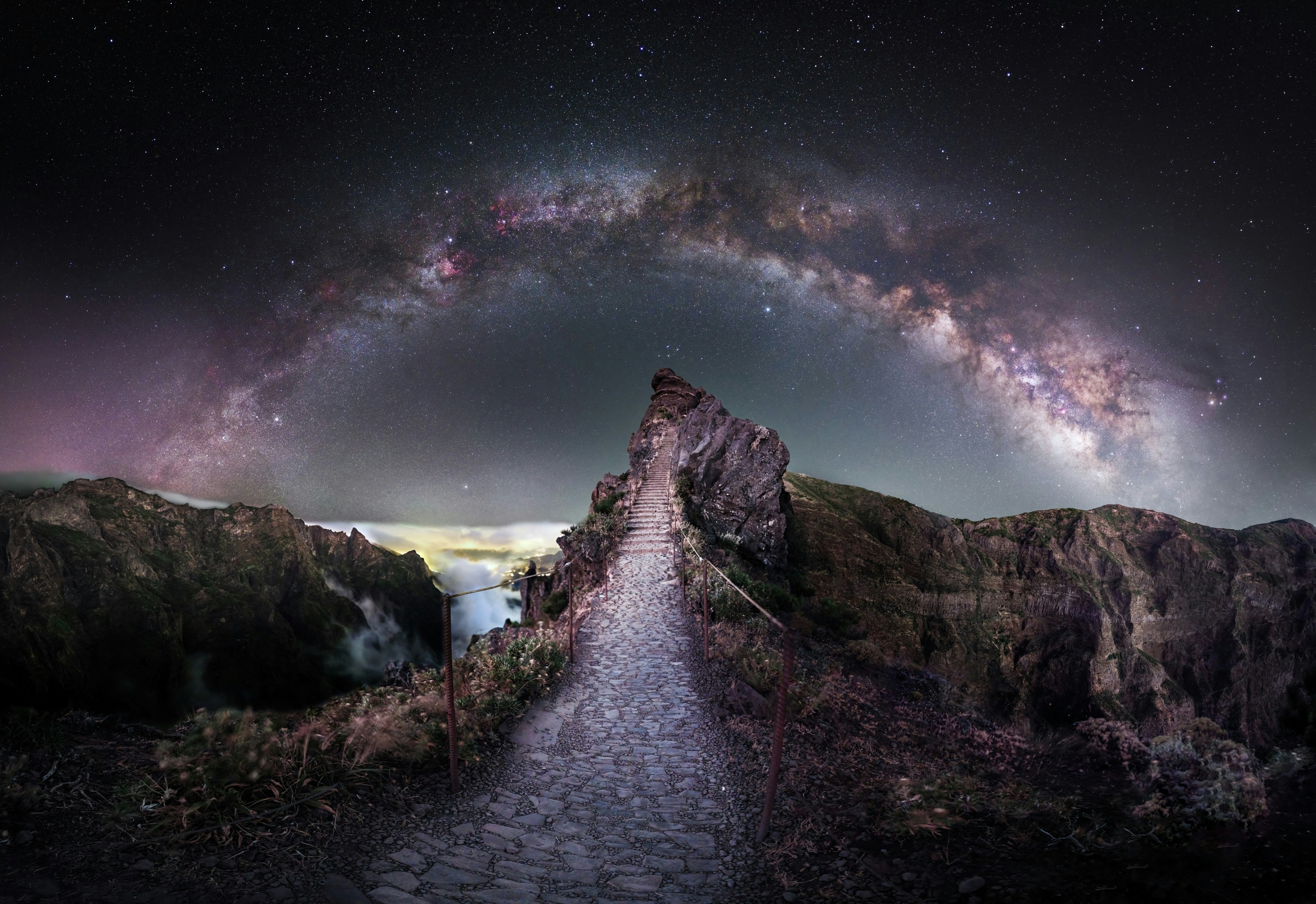 Milky way arching over a rocky mountain path