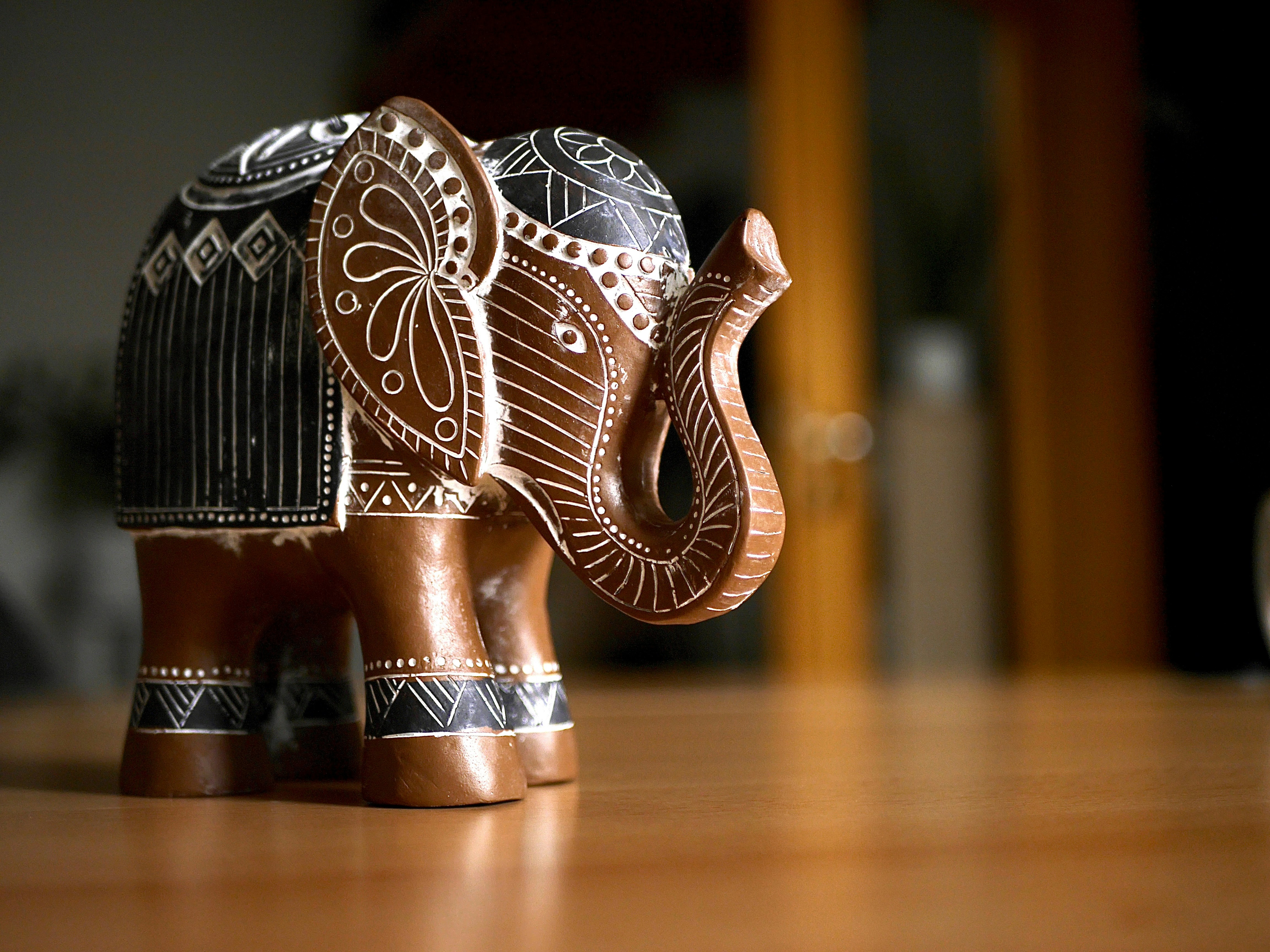 Ornate wooden elephant figurine on a wooden surface.