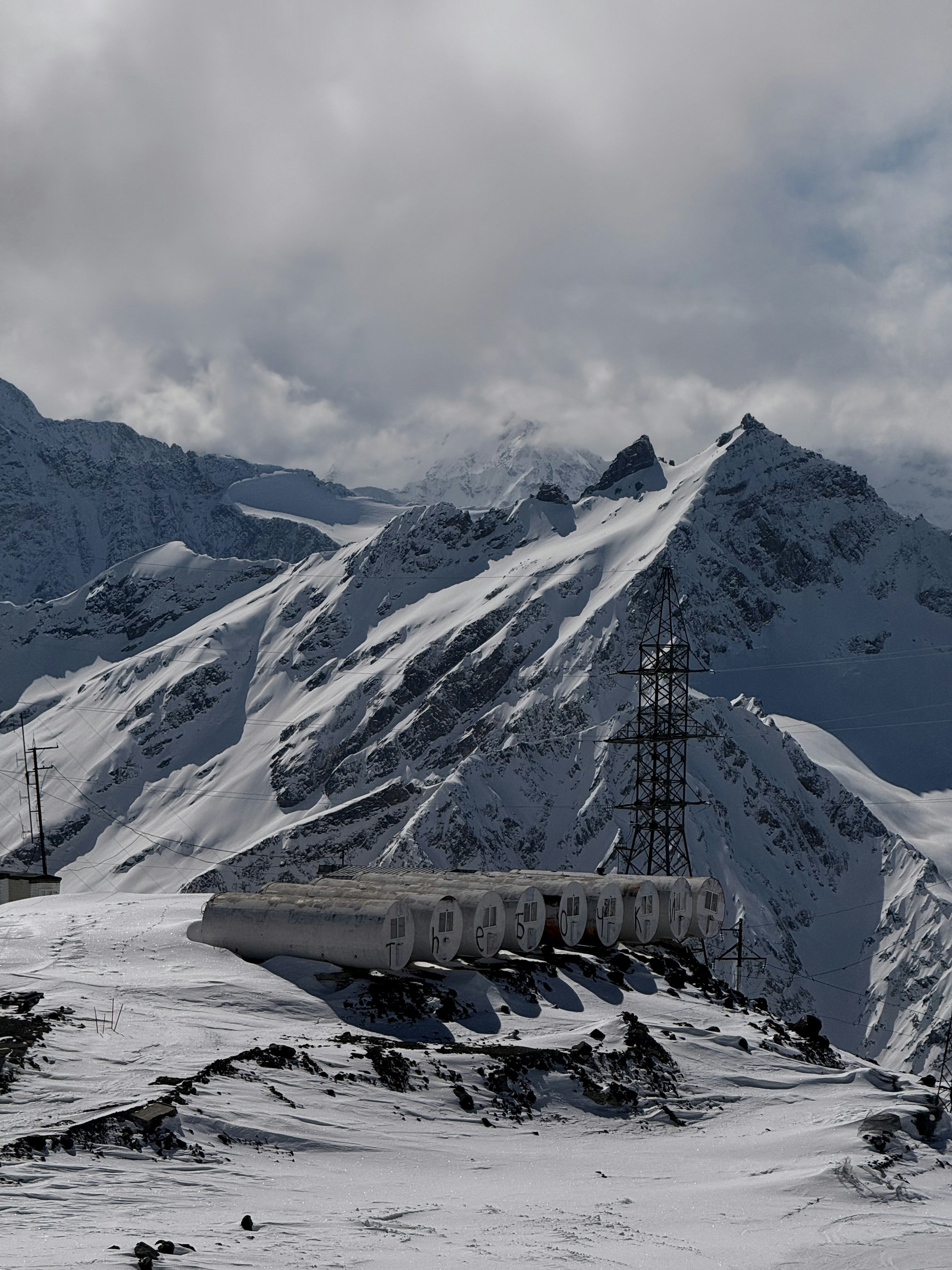 Snowy mountain range with a small building and tower