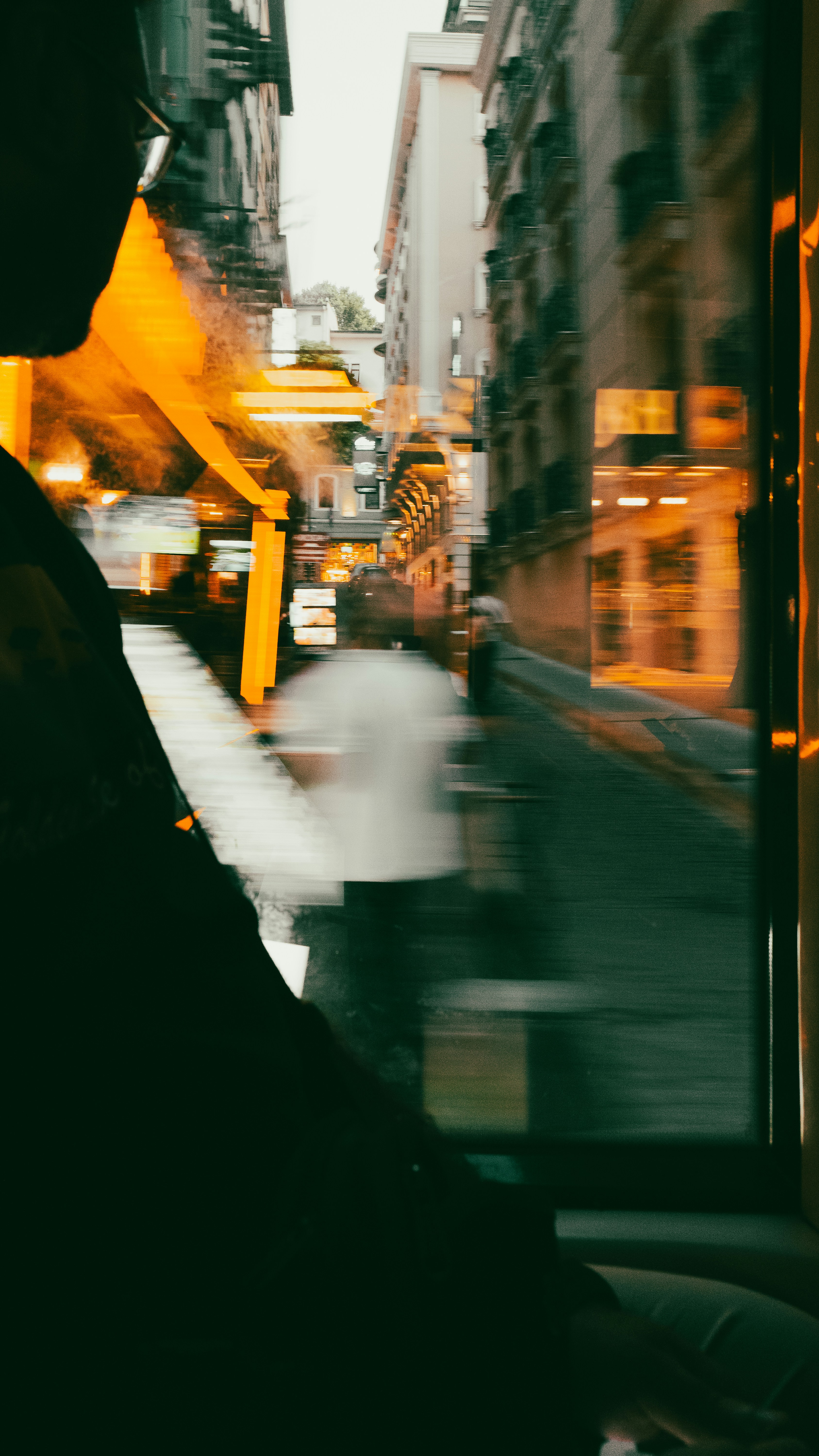 Cena de rua borrada com luzes brilhantes ao entardecer.
