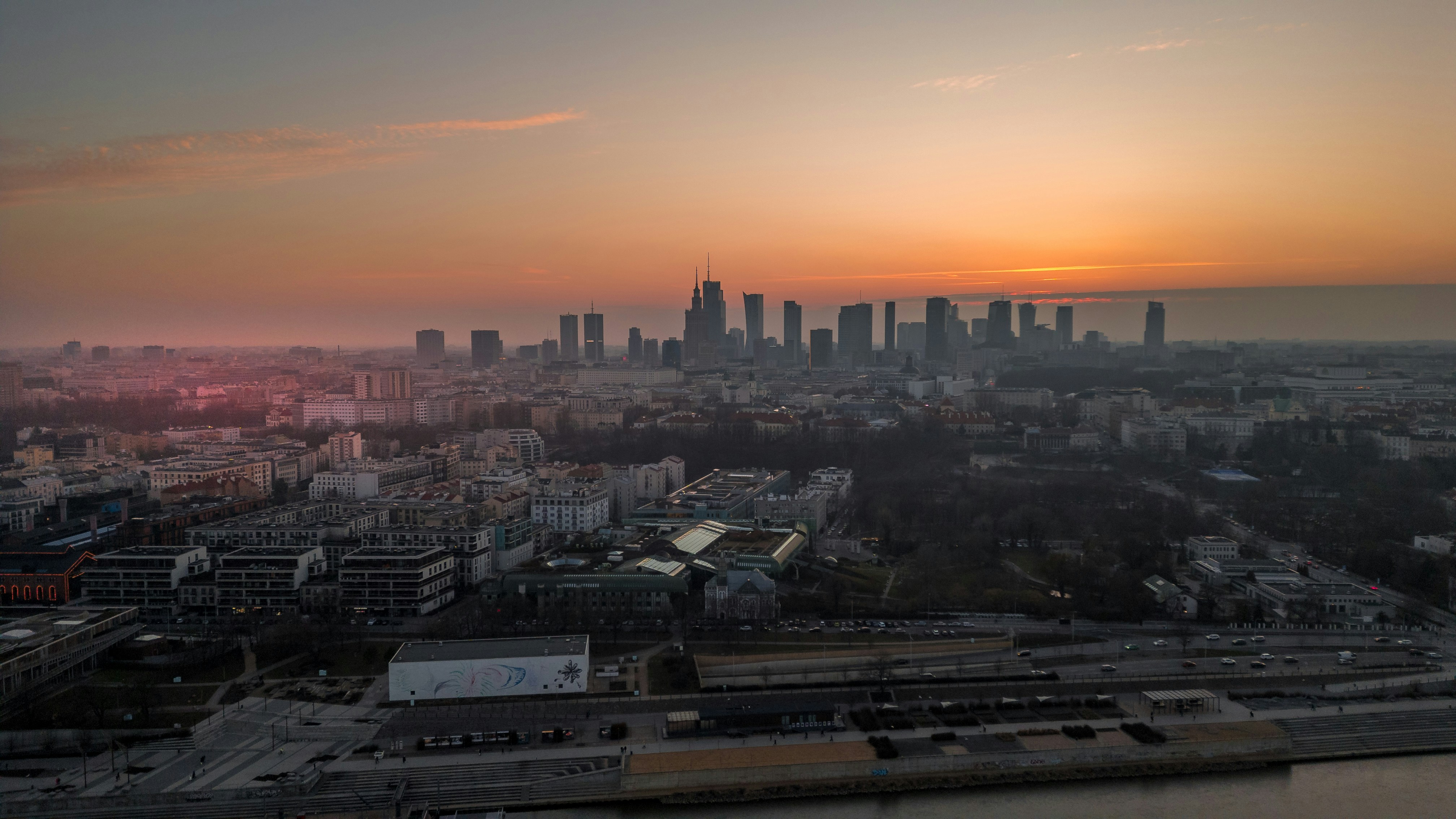 El skyline de la ciudad al atardecer con cielo brumoso y edificios modernos.