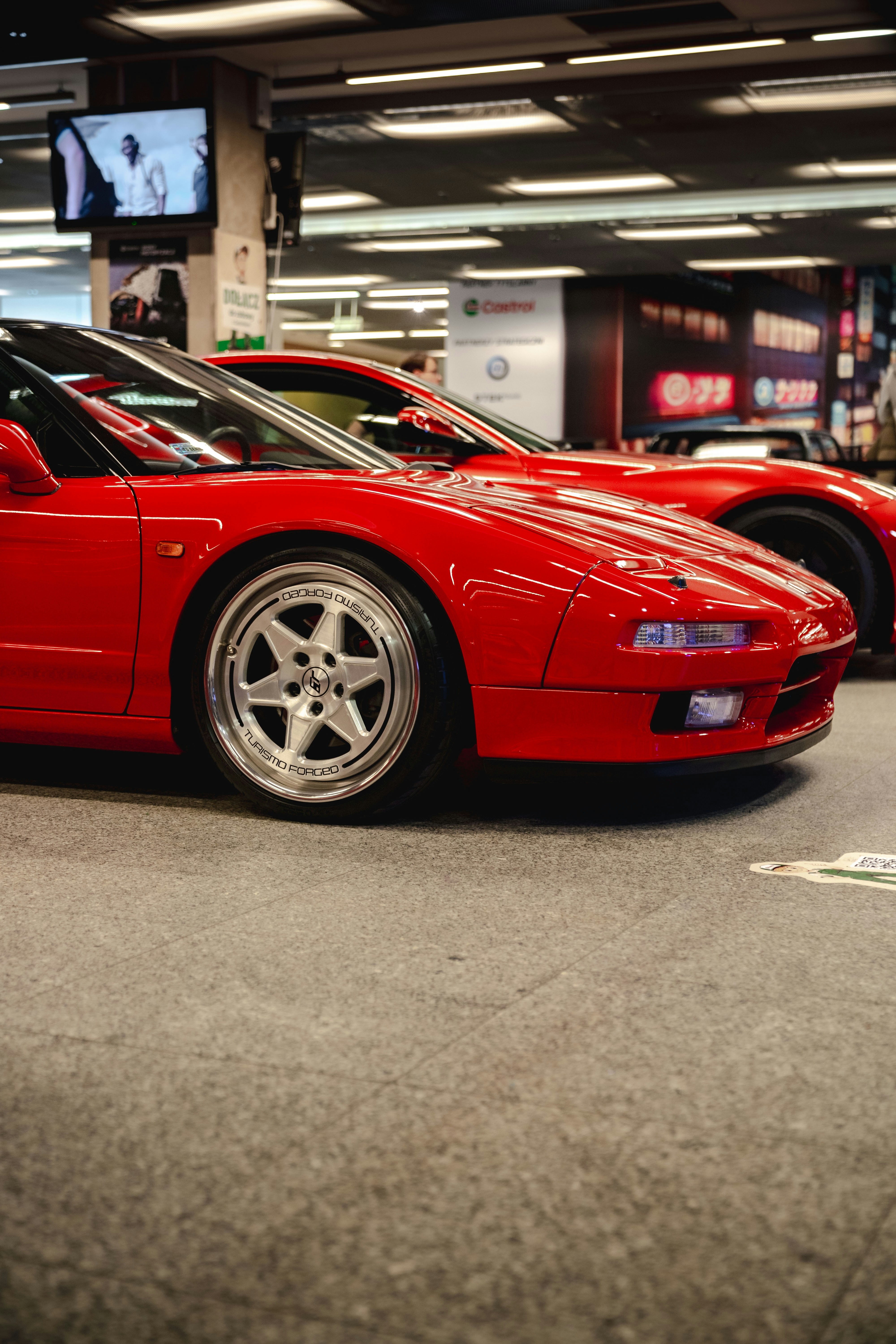 Dos coches deportivos rojos aparcados en interiores