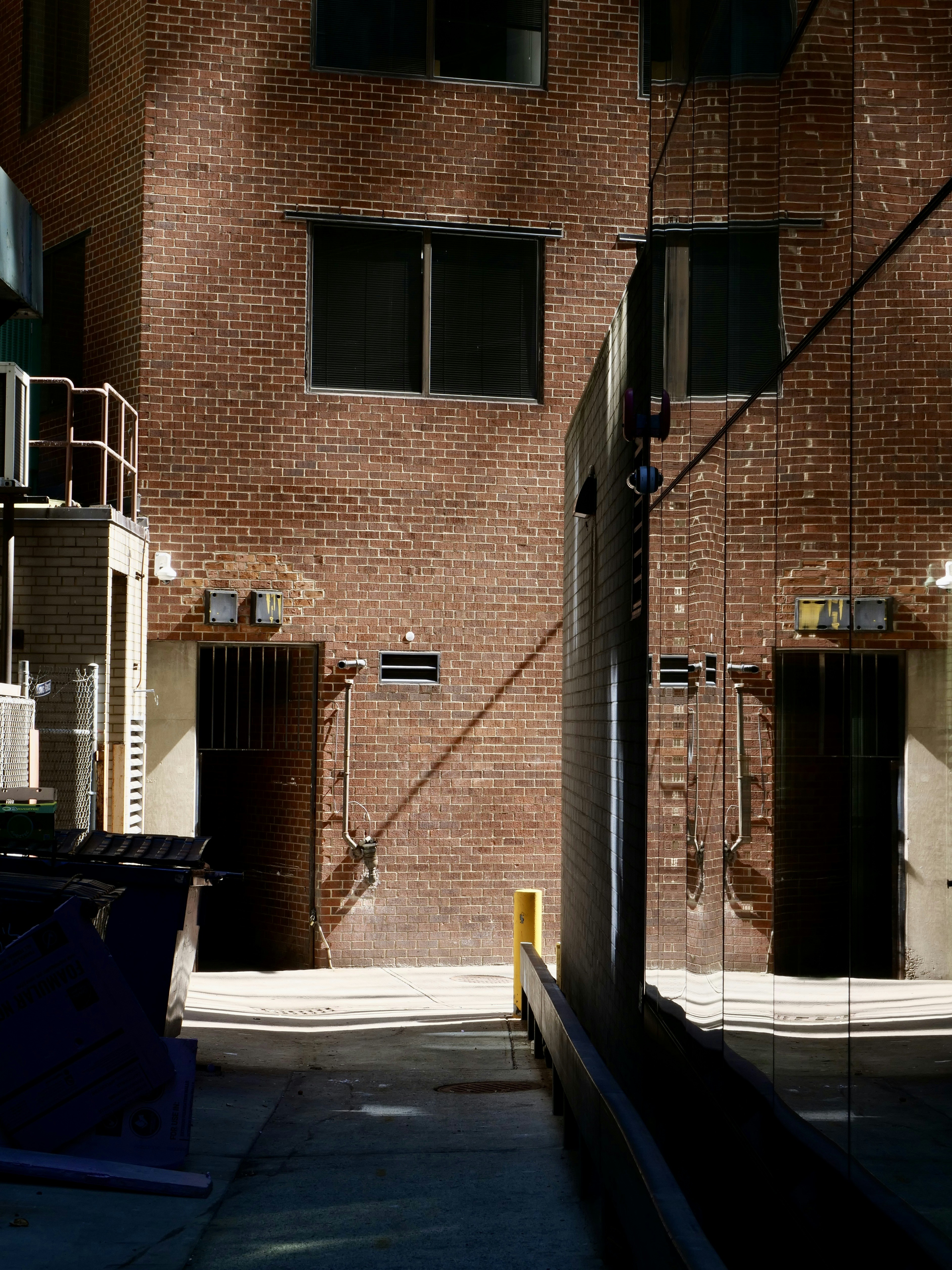 Brick building exterior with two dark doors and windows.