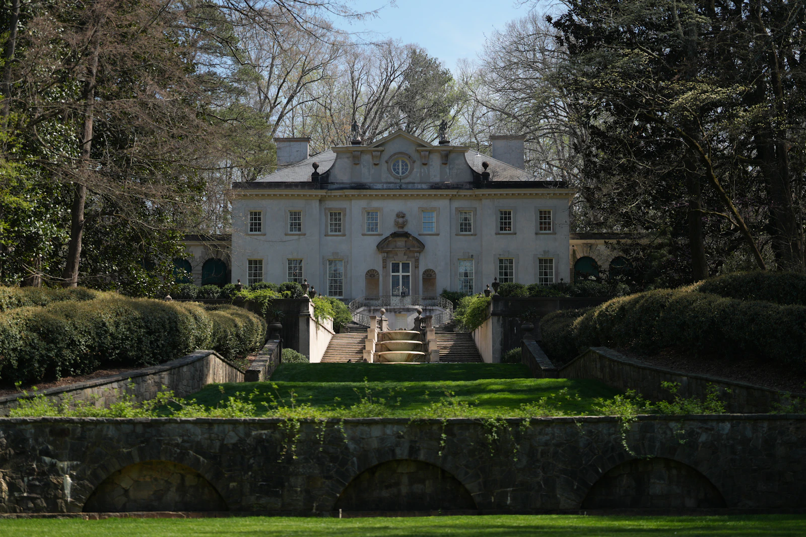 A stone house above terraced lawns and clipped gardens