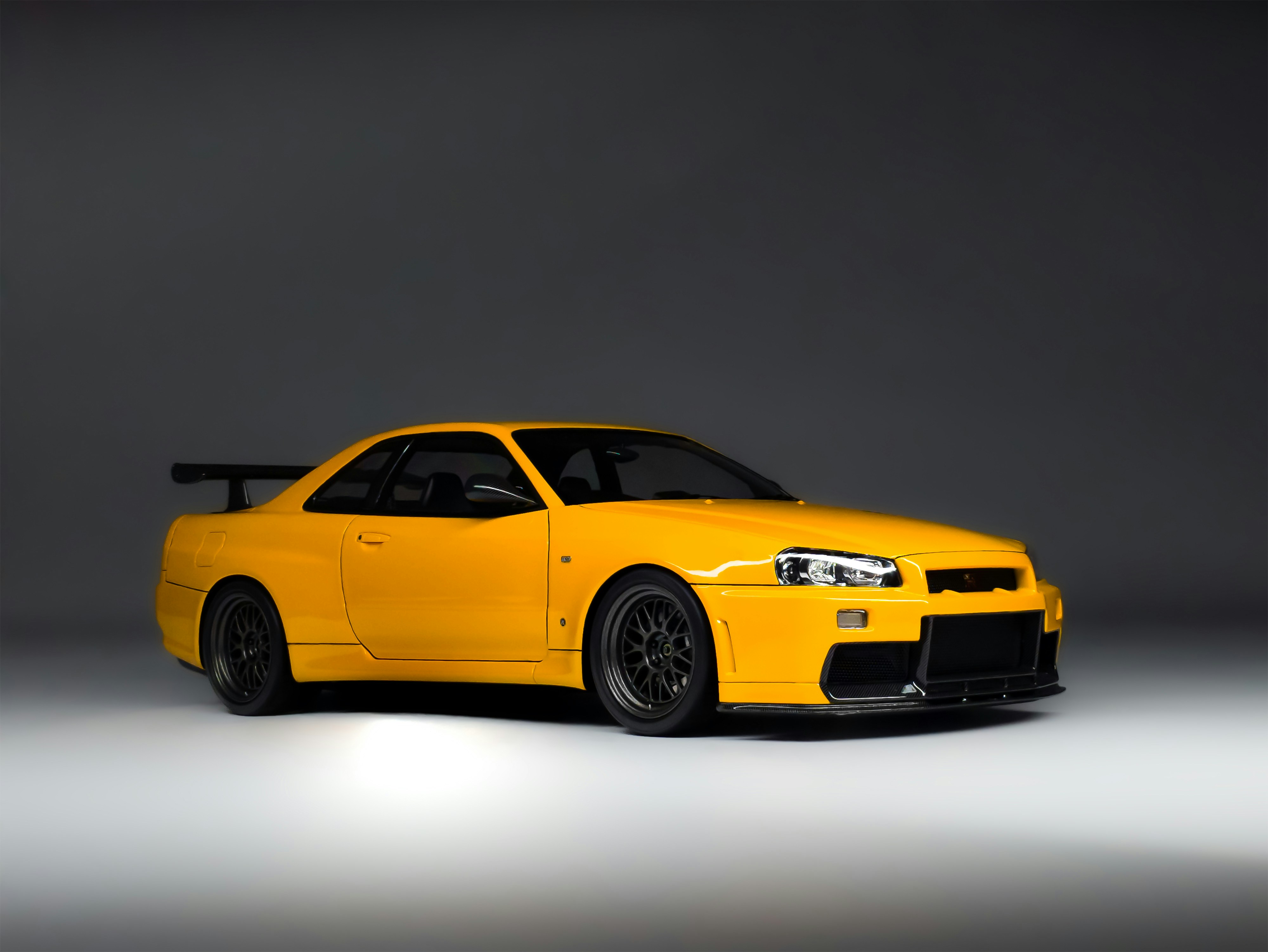 A bright yellow sports car with a spoiler