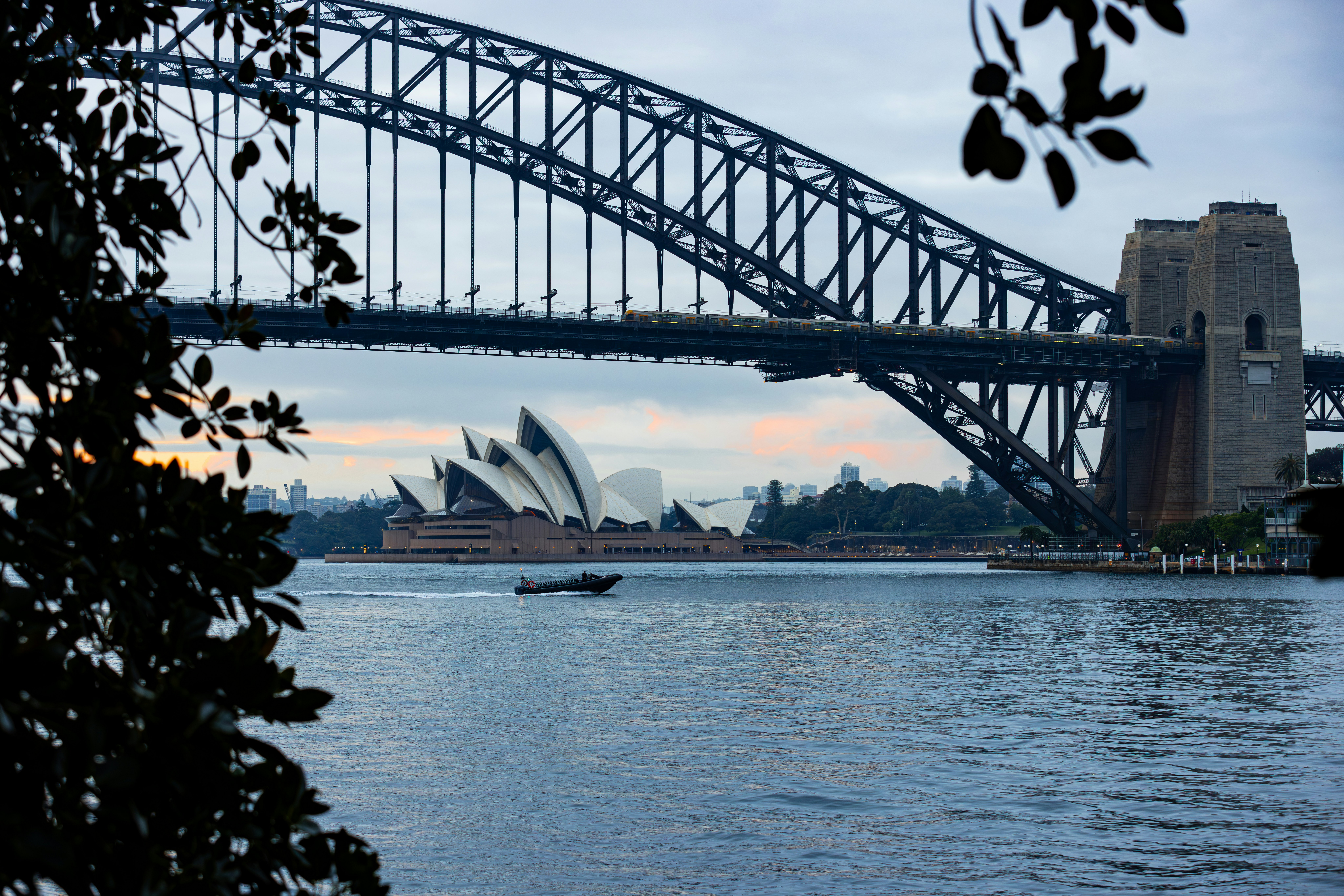 Sydney harbour bridge and opera house with boat on water