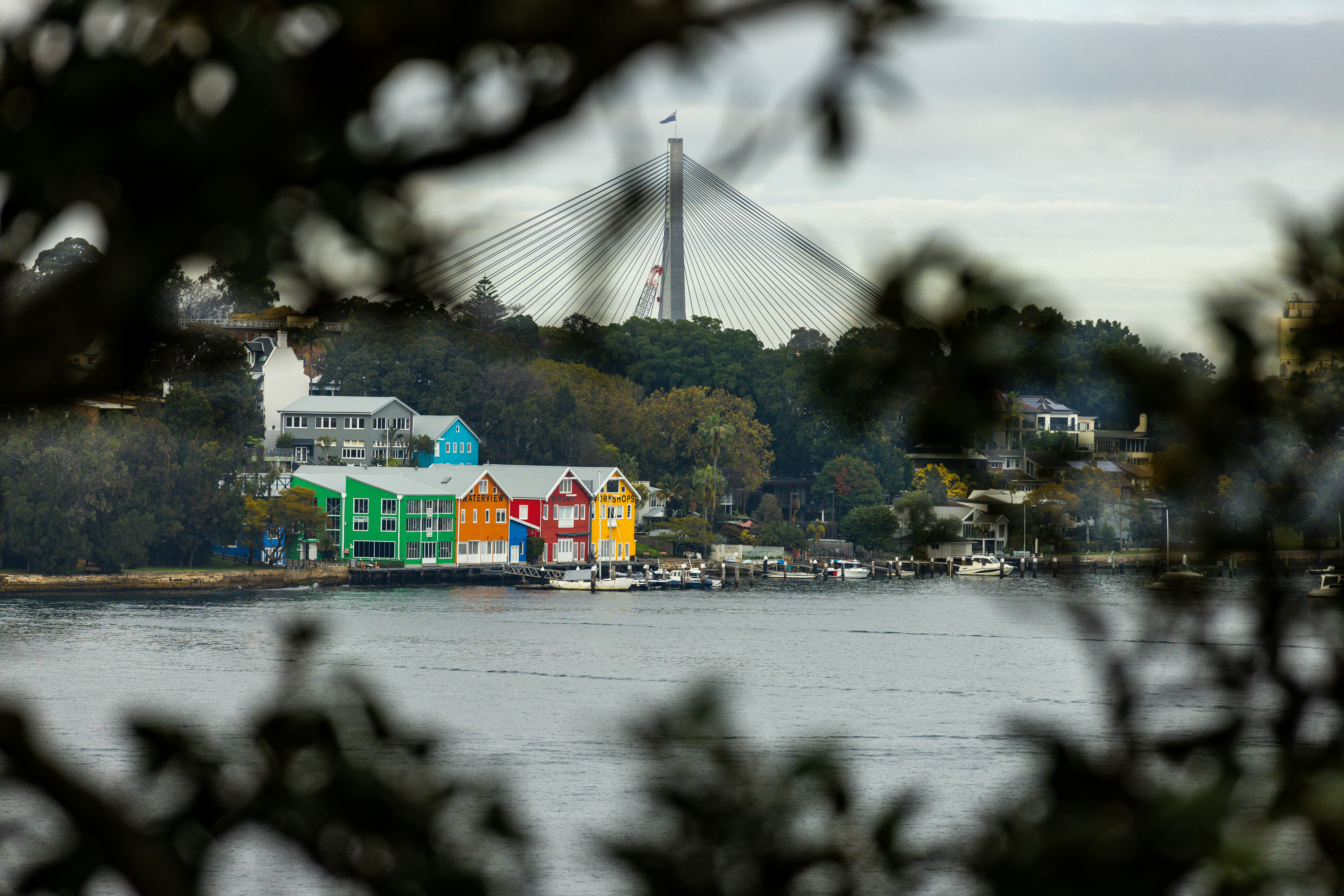 Colorful buildings on a waterfront with a bridge in background.