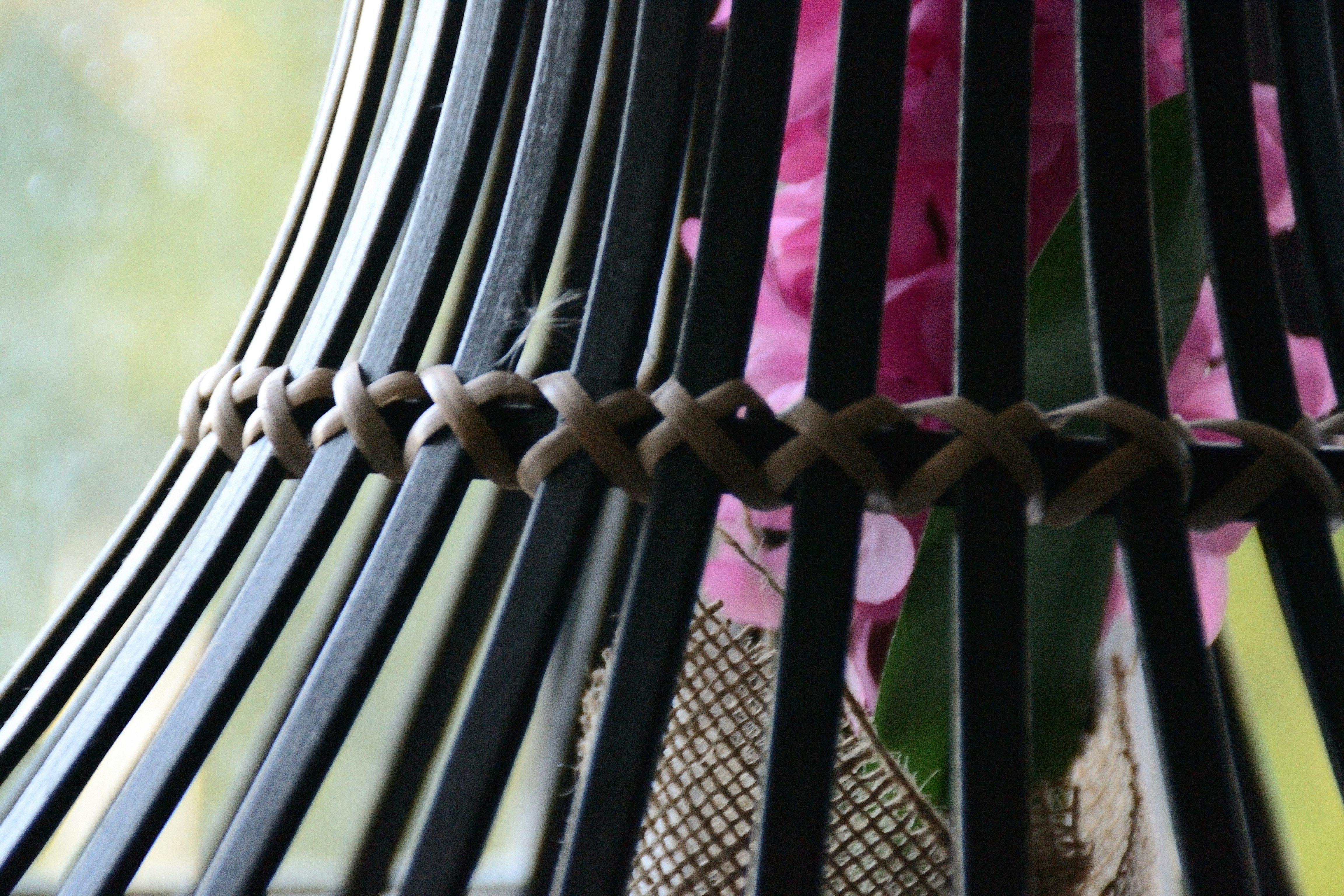 Primer plano de una cesta oscura tejida con flores rosas