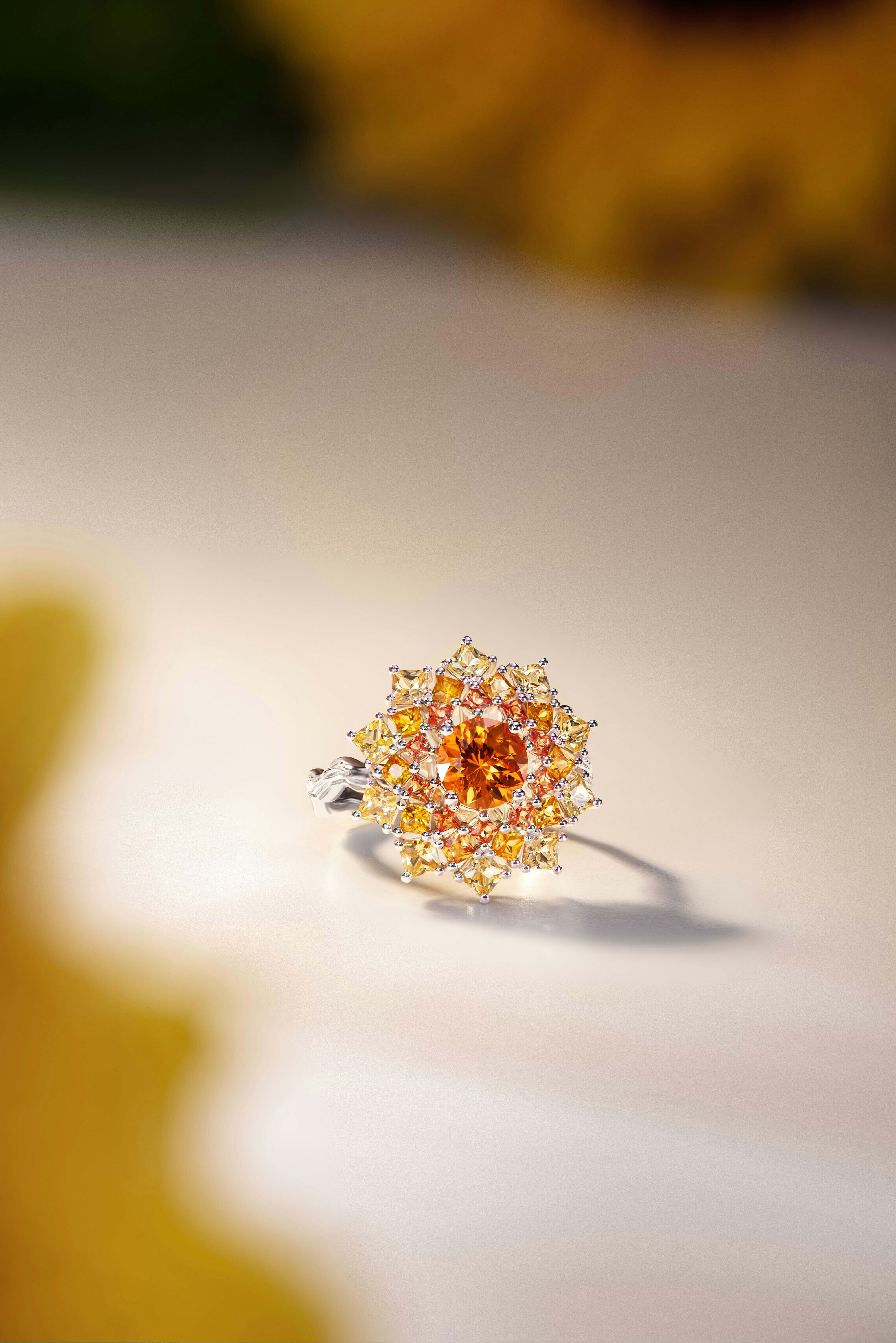 Une bague en diamant étincelante avec des pierres orange et jaune.