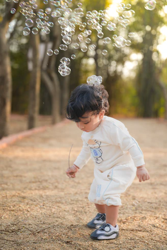 A young child plays with bubbles outdoors.