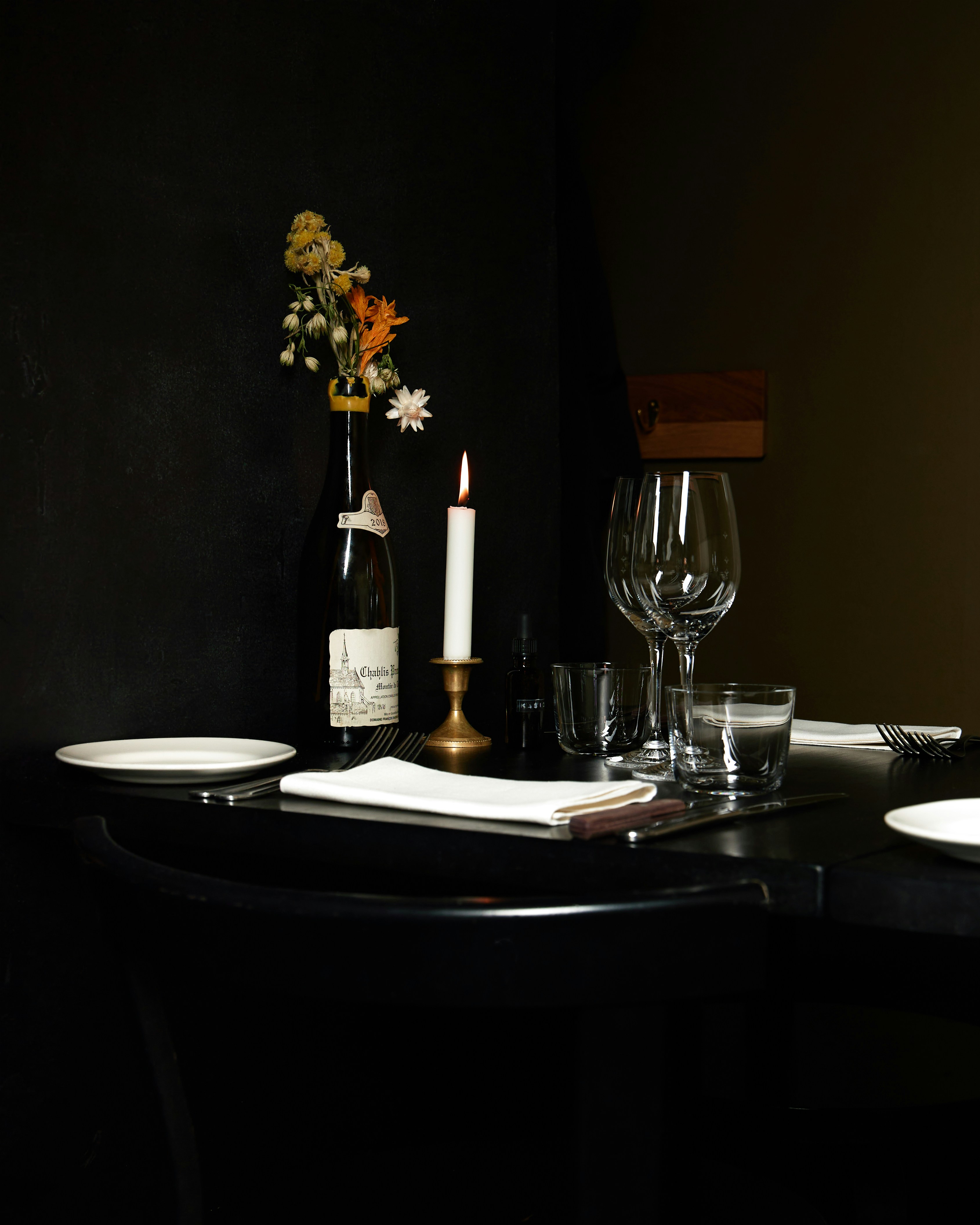 Una mesa a la luz de las velas, con vino y flores