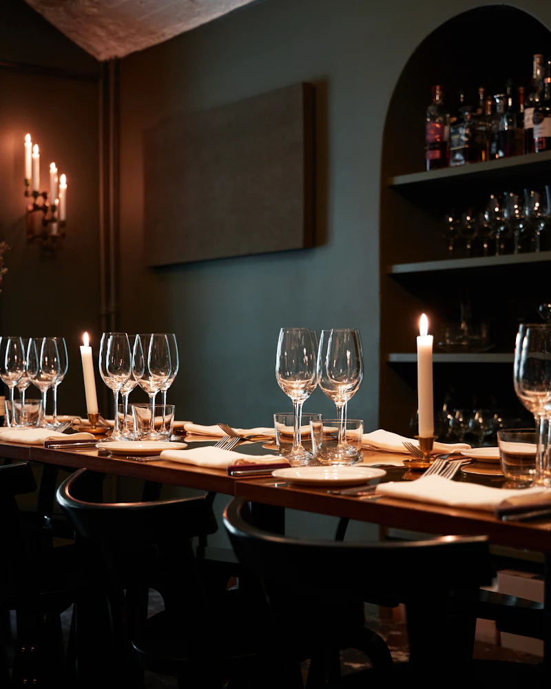 Table de restaurant dressée verres à vin et bougies