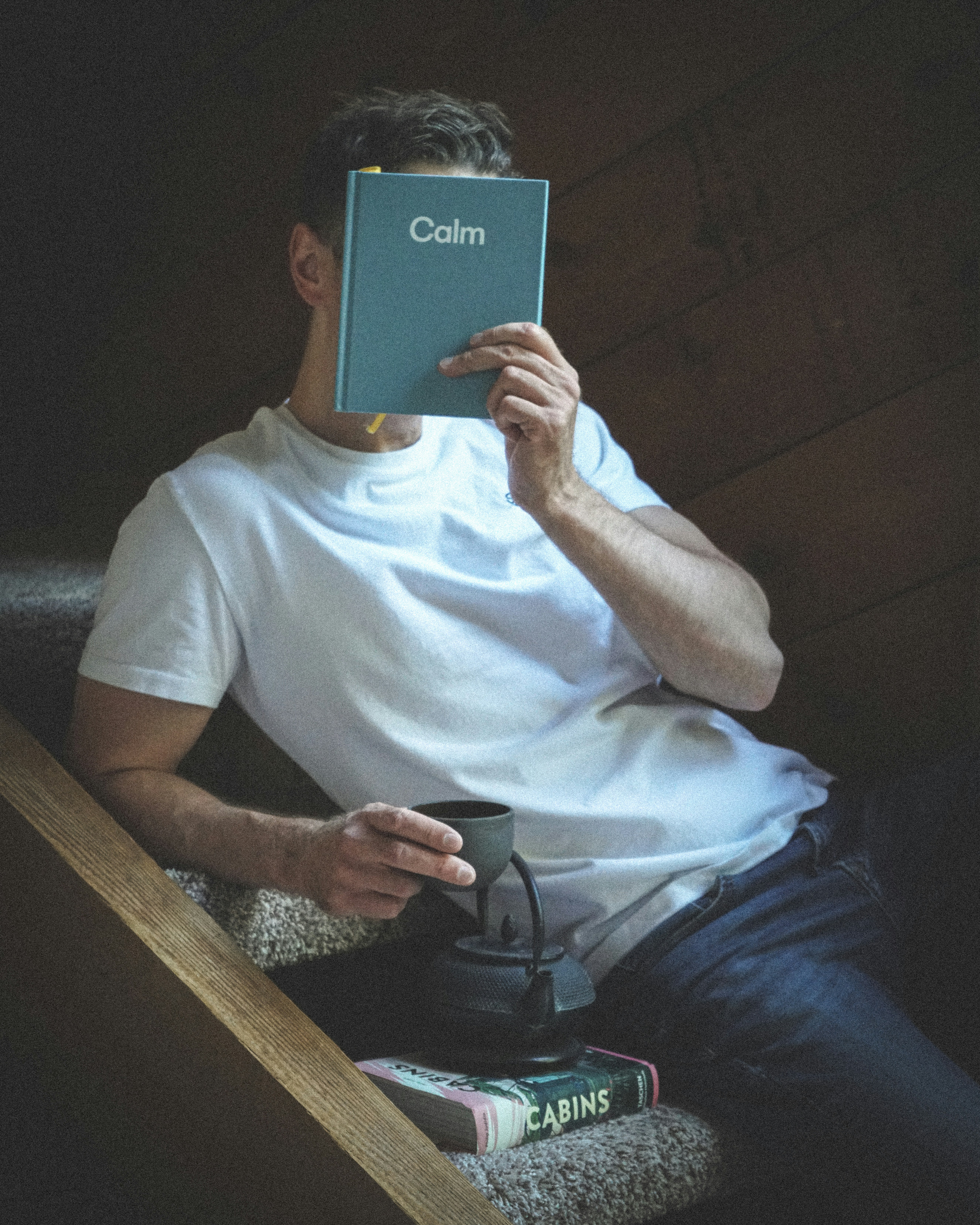 Homme assis dans les escaliers en train de lire un livre intitulé calme
