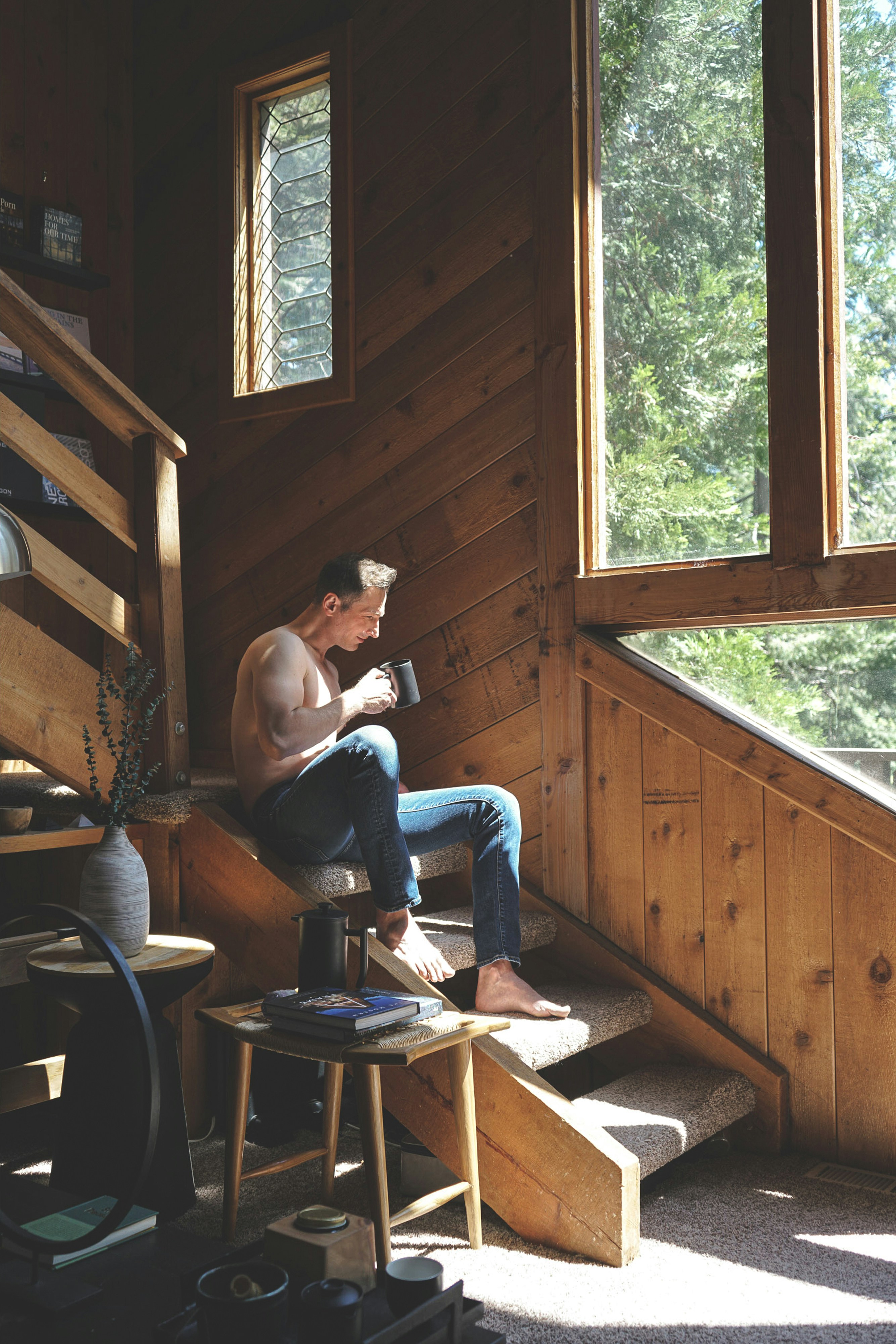 Man sitting on wooden stairs with a mug