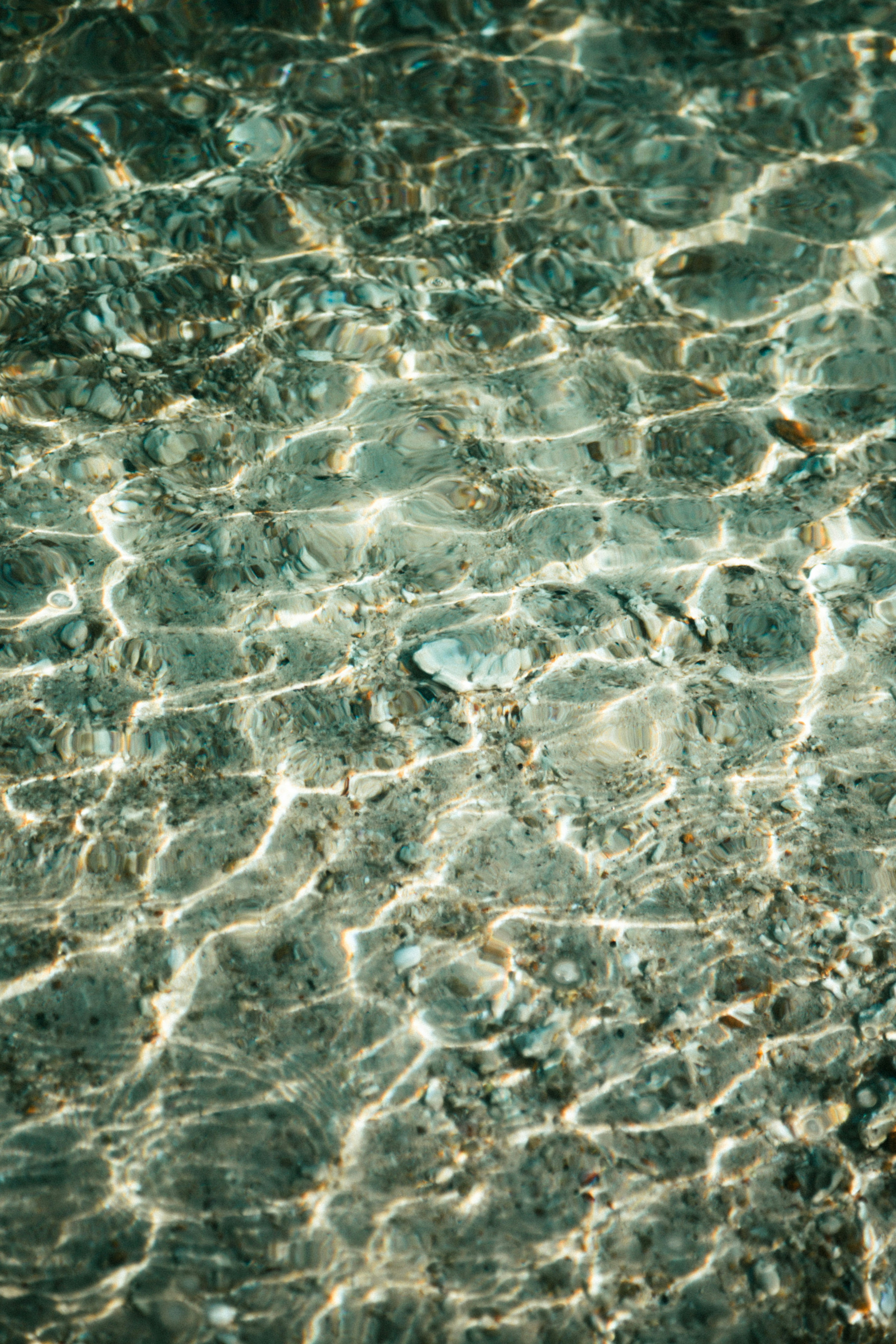 Padrões de luz solar em um fundo rochoso do mar