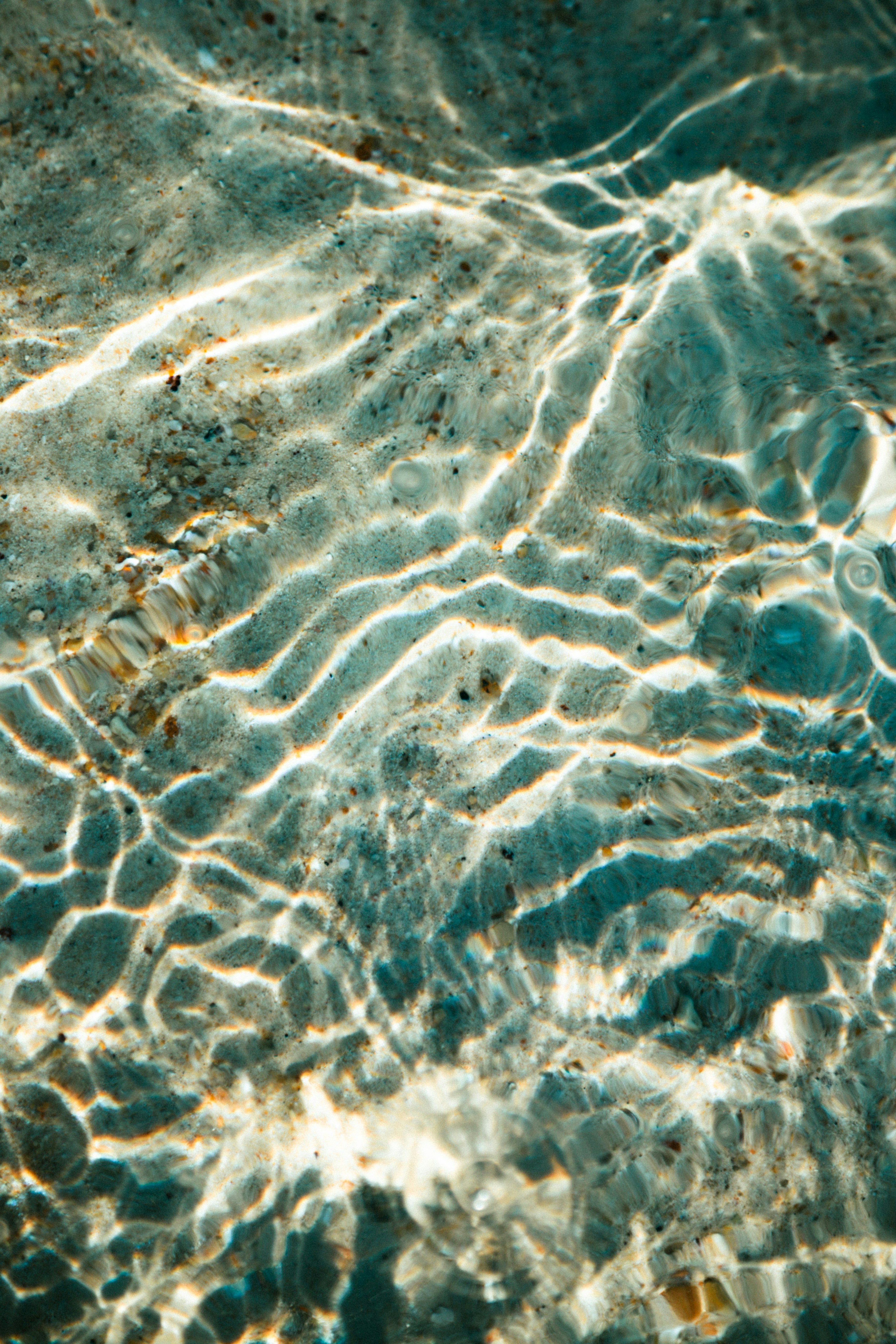 Padrões de luz solar no fundo arenoso do oceano