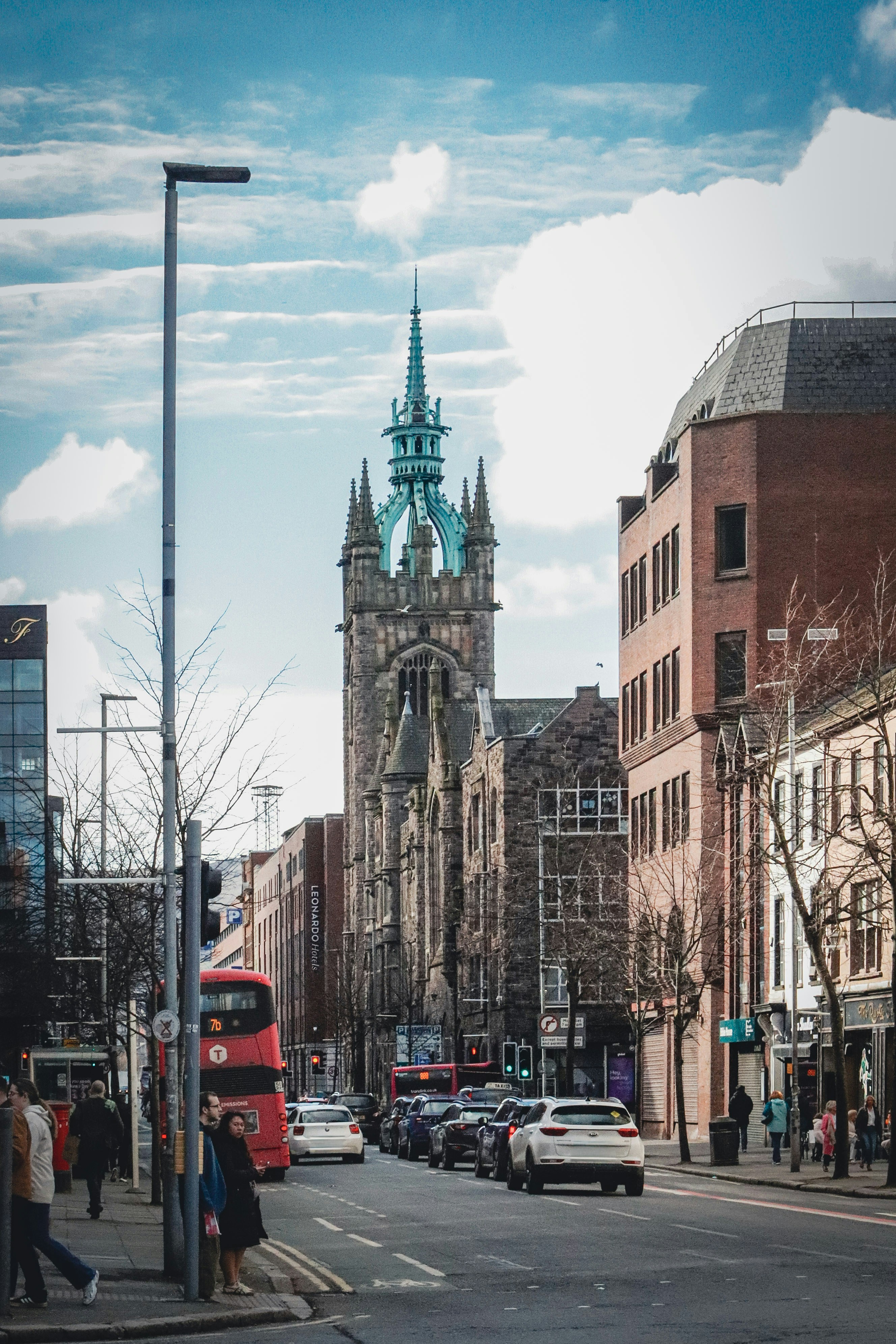 歴史的な教会と赤いバスがあるシティストリート。