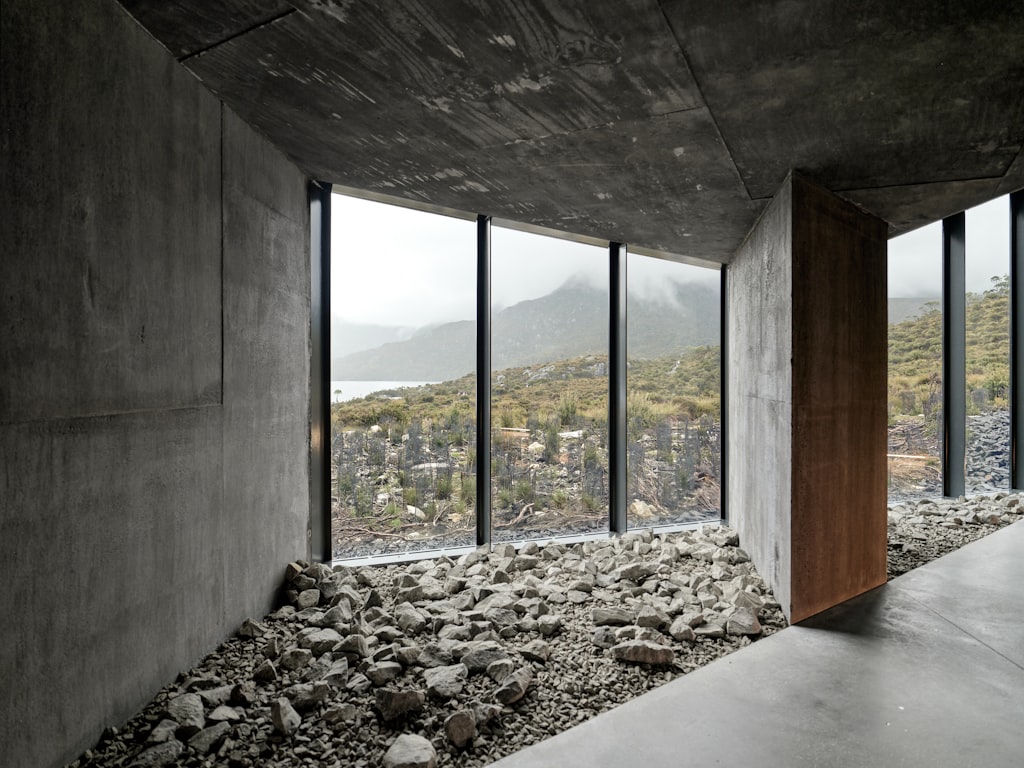 Refugi: A modern concrete mountain retreat with floor-to-ceiling windows overlooking a dramatic landscape