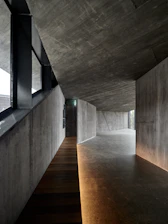 Modern concrete interior with wooden walkway and soft lighting