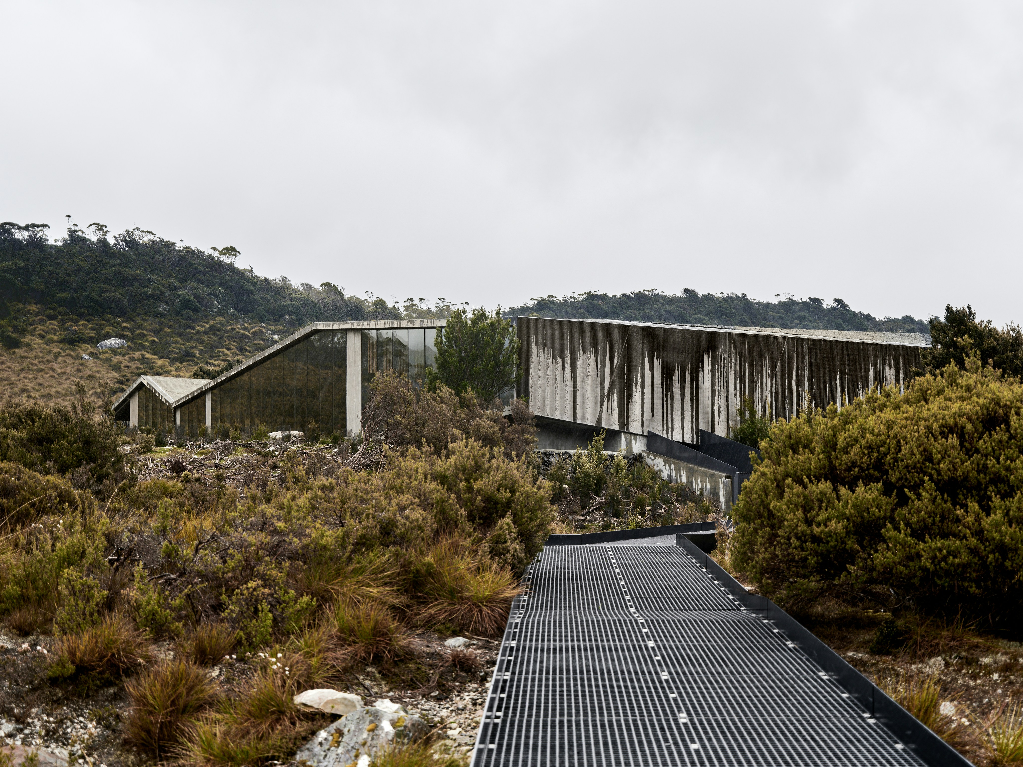 Modern buildings nestled in a rugged, natural landscape.