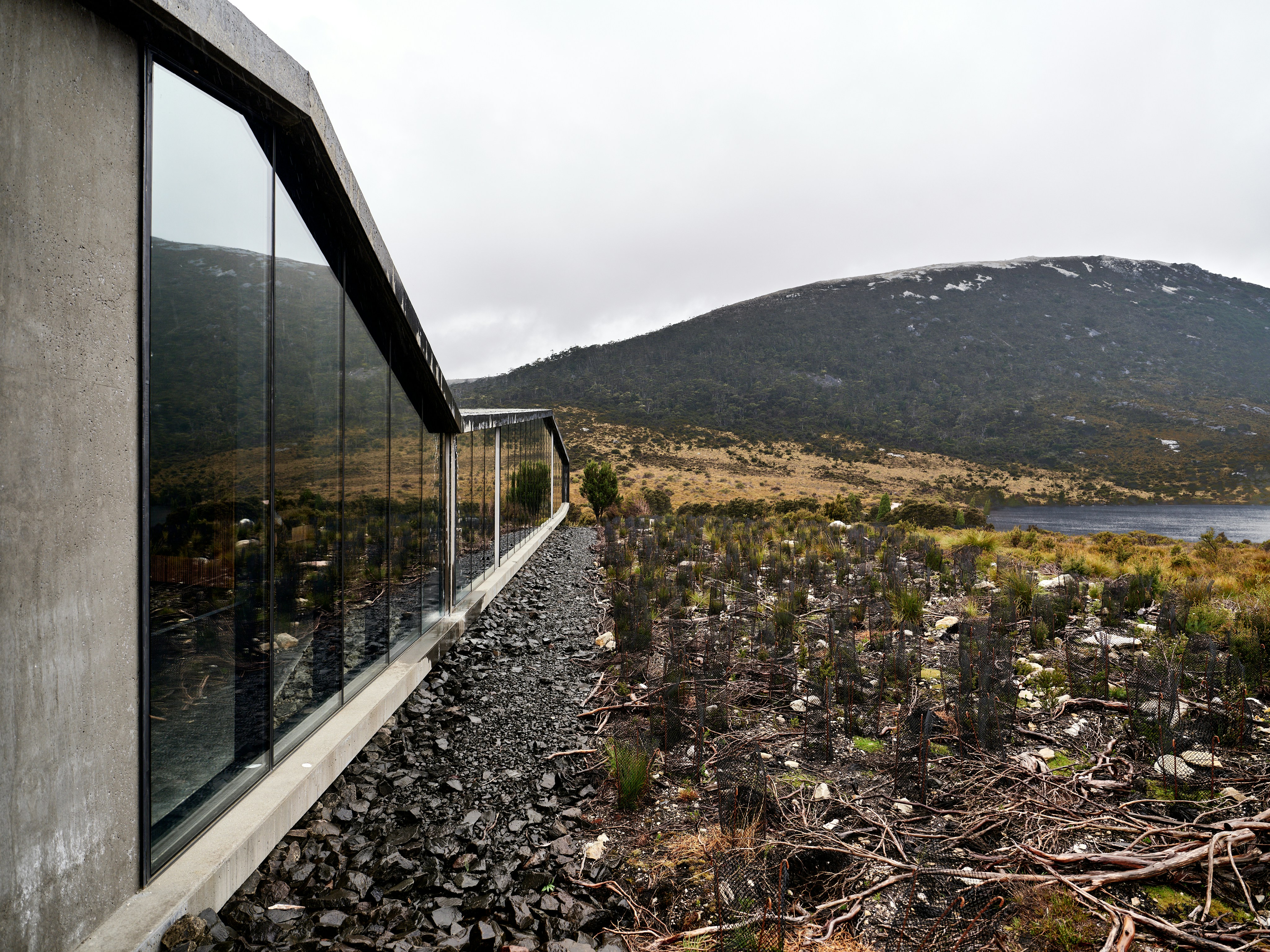Modern building with large windows overlooking a desolate landscape.