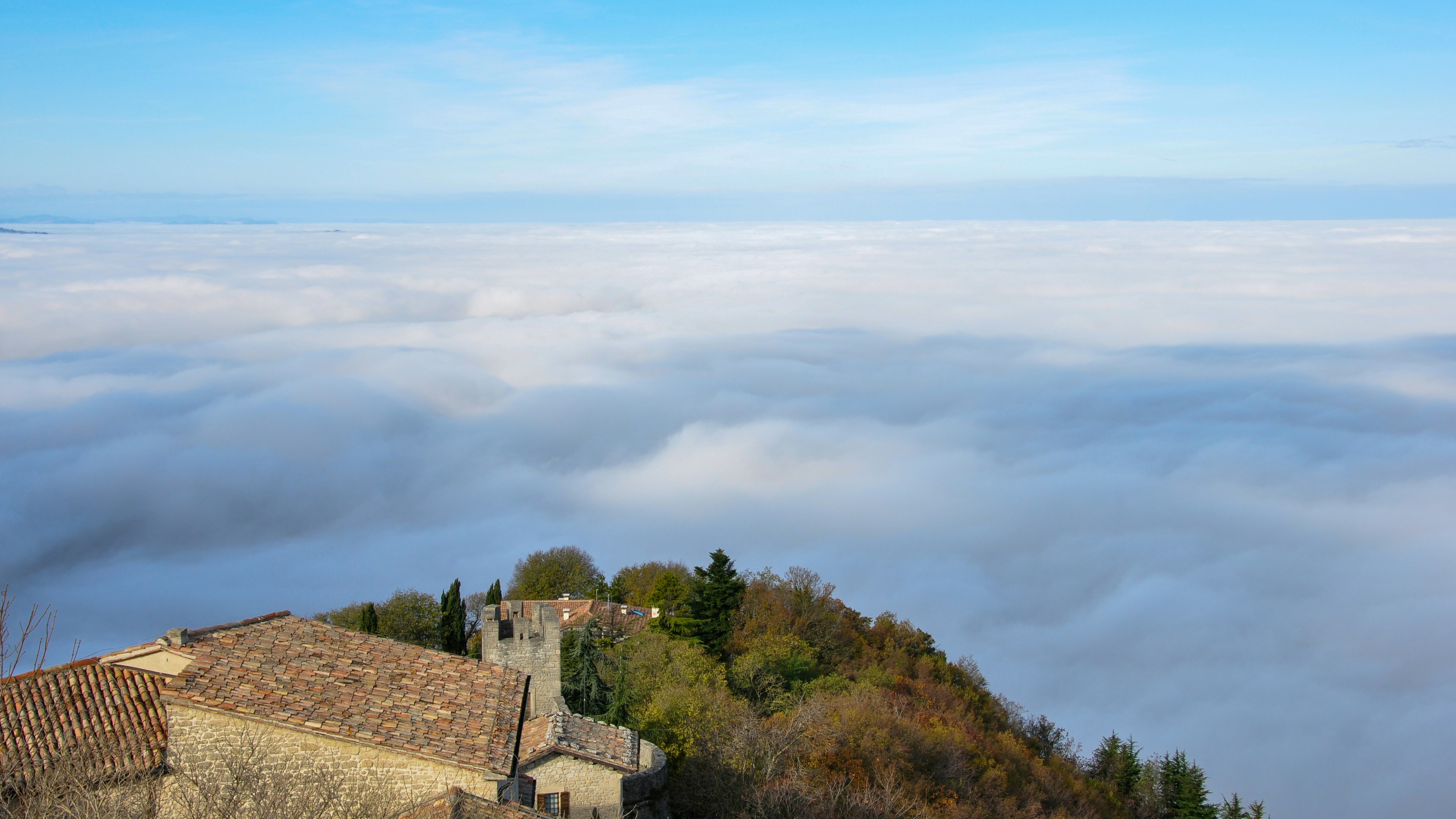 Castle ruins on a hill above clouds