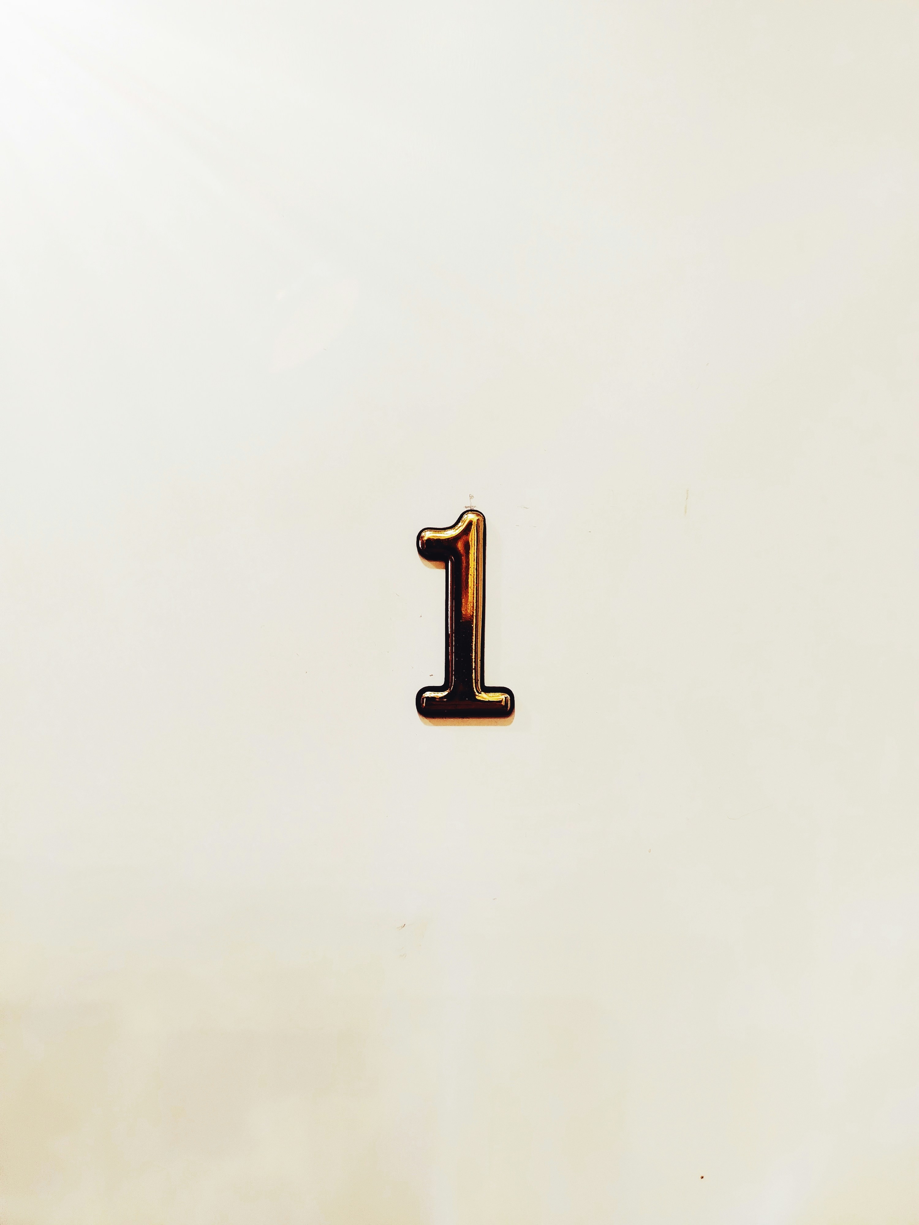A single metallic number one on a light background