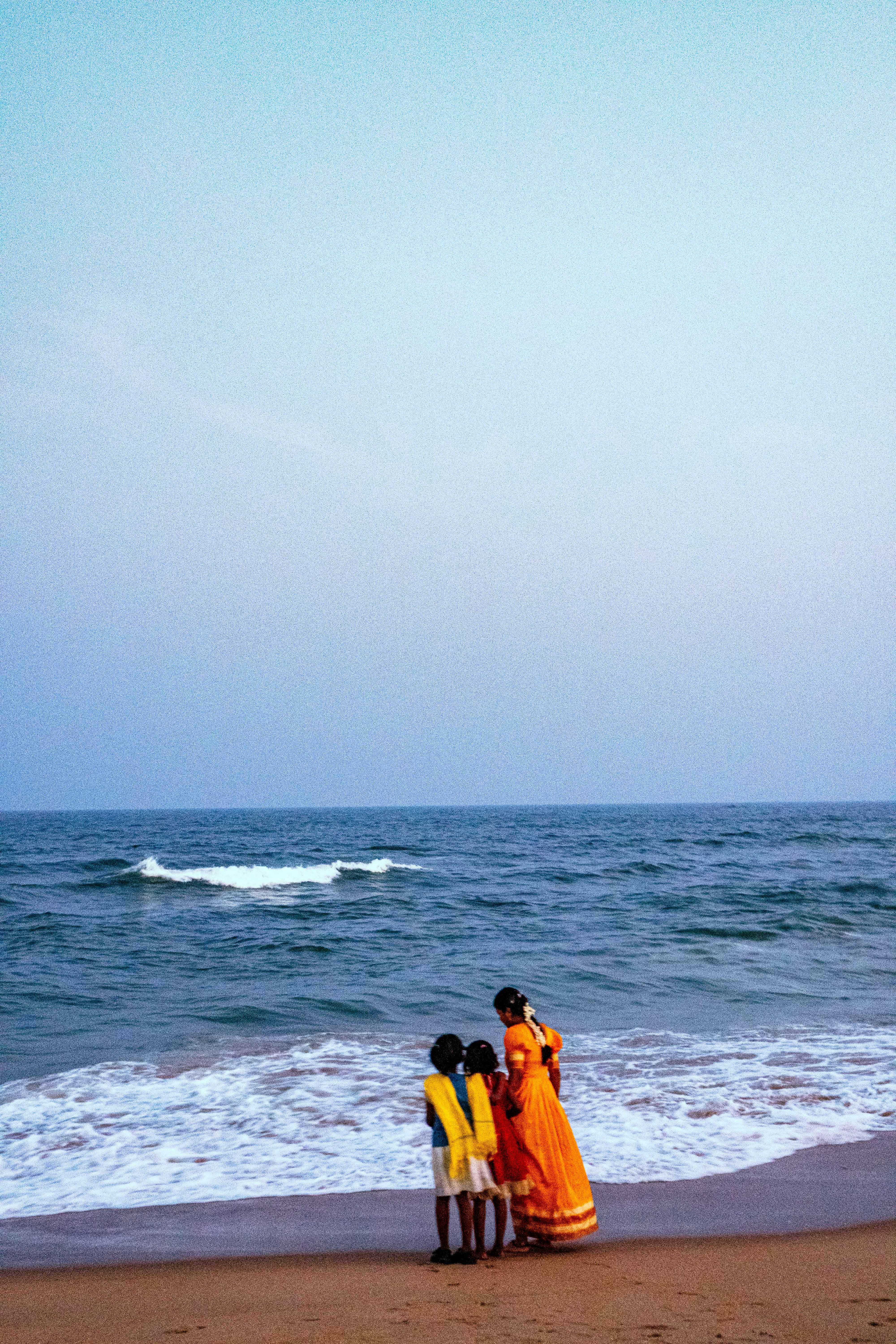 Familia de pie en una playa junto al mar