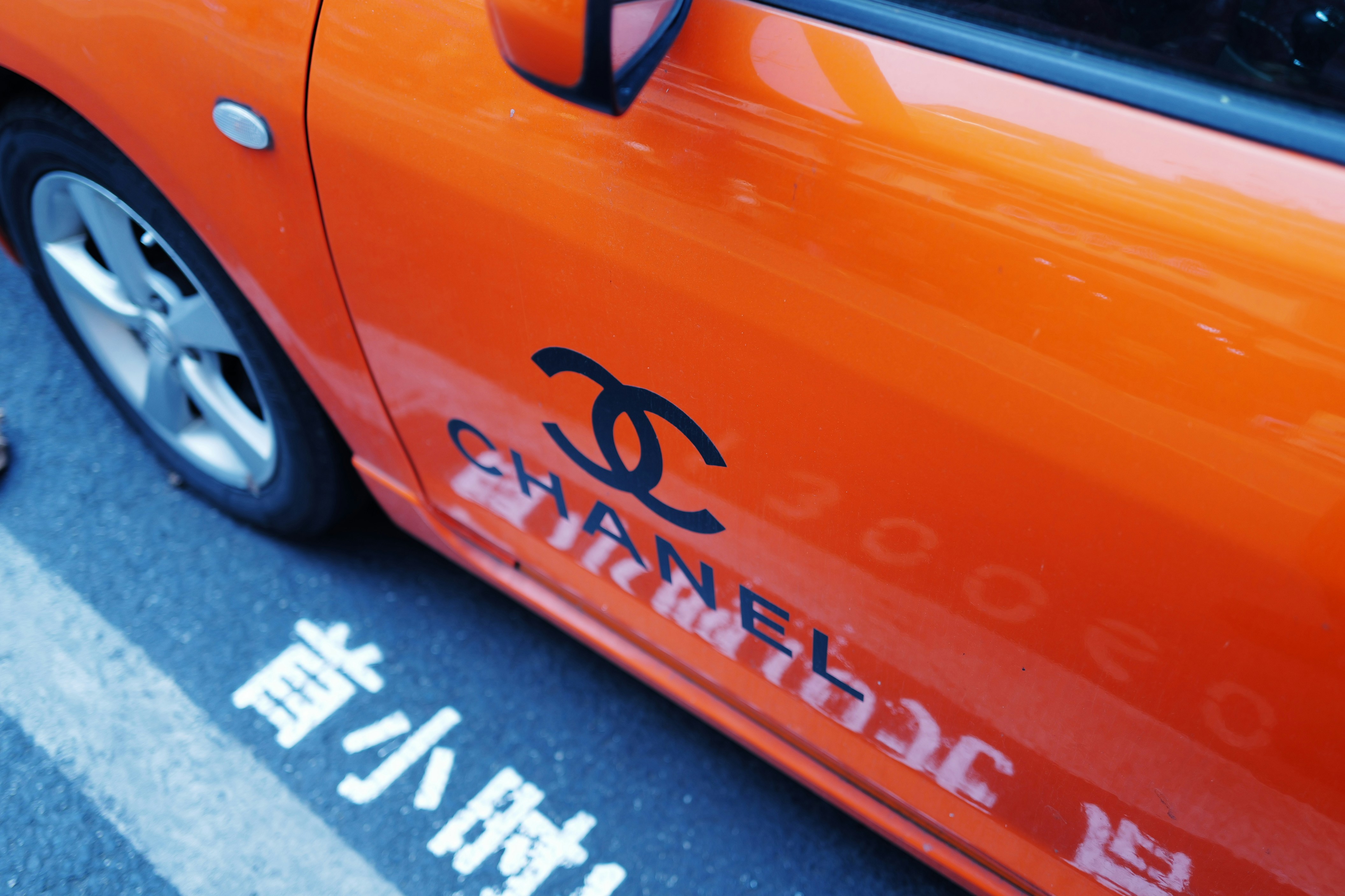 Orange car with chanel logo and text