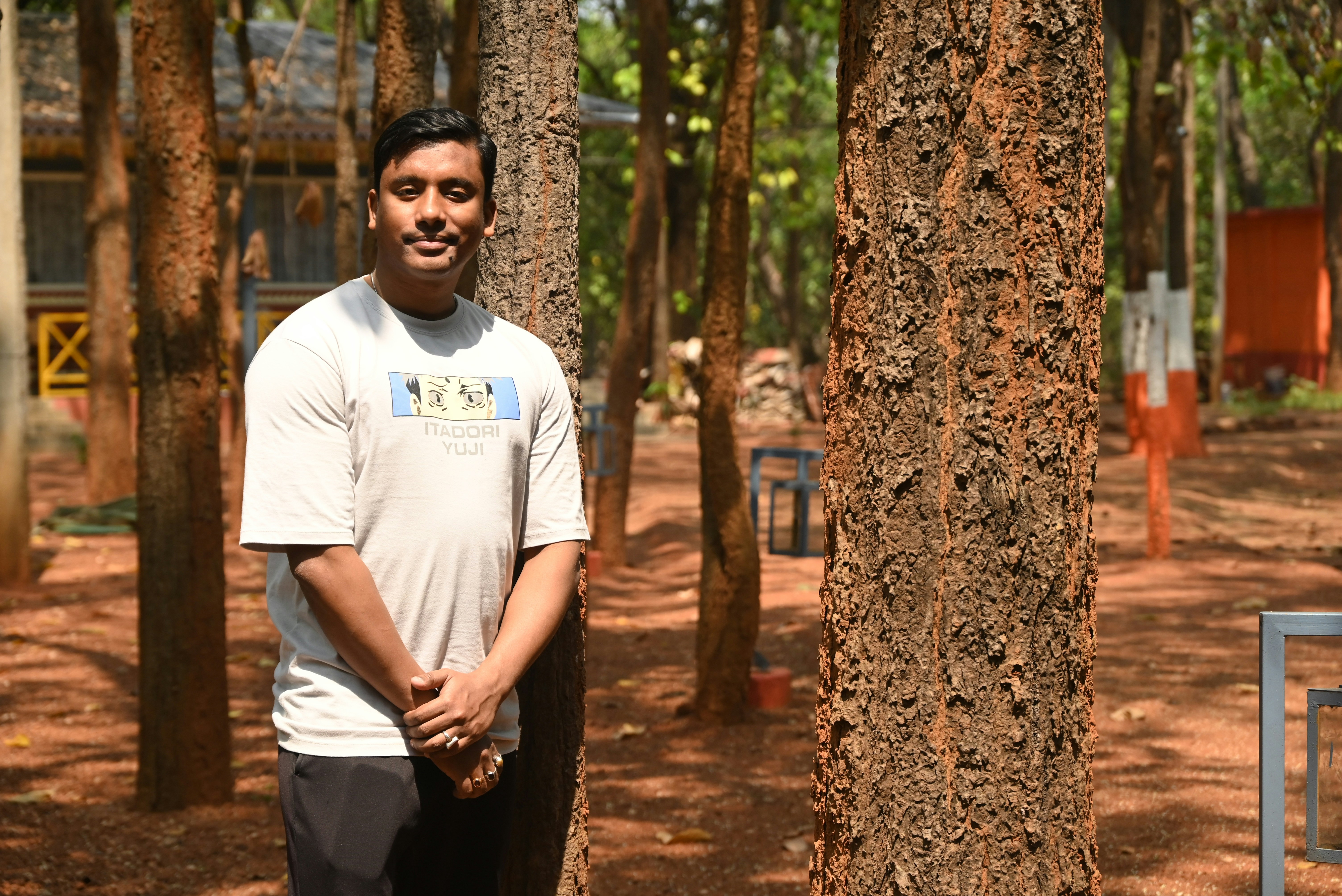 Ein junger Mann steht in einem Wald voller Bäume.
