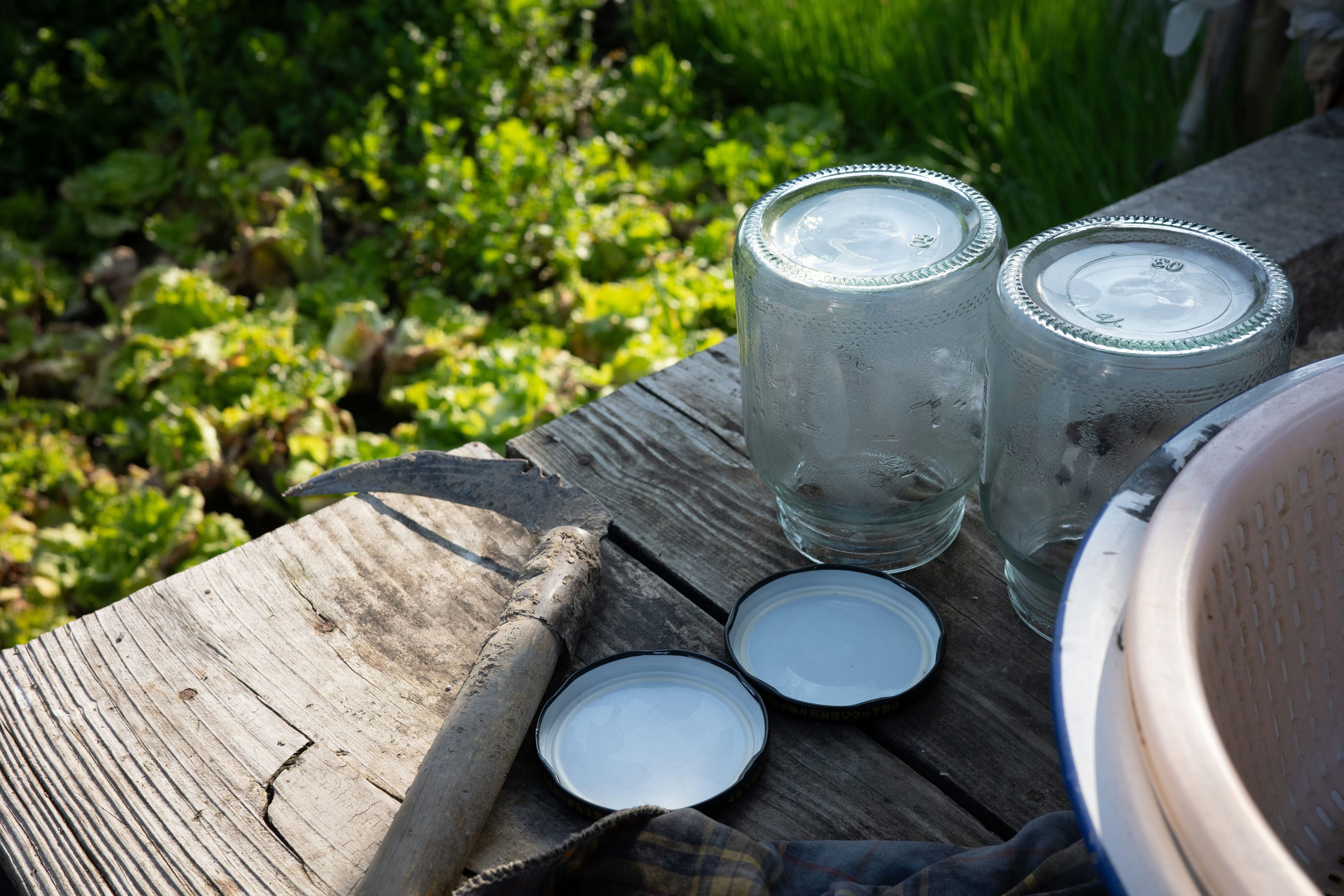 Dois potes de vidro e tampas sobre tábuas de madeira