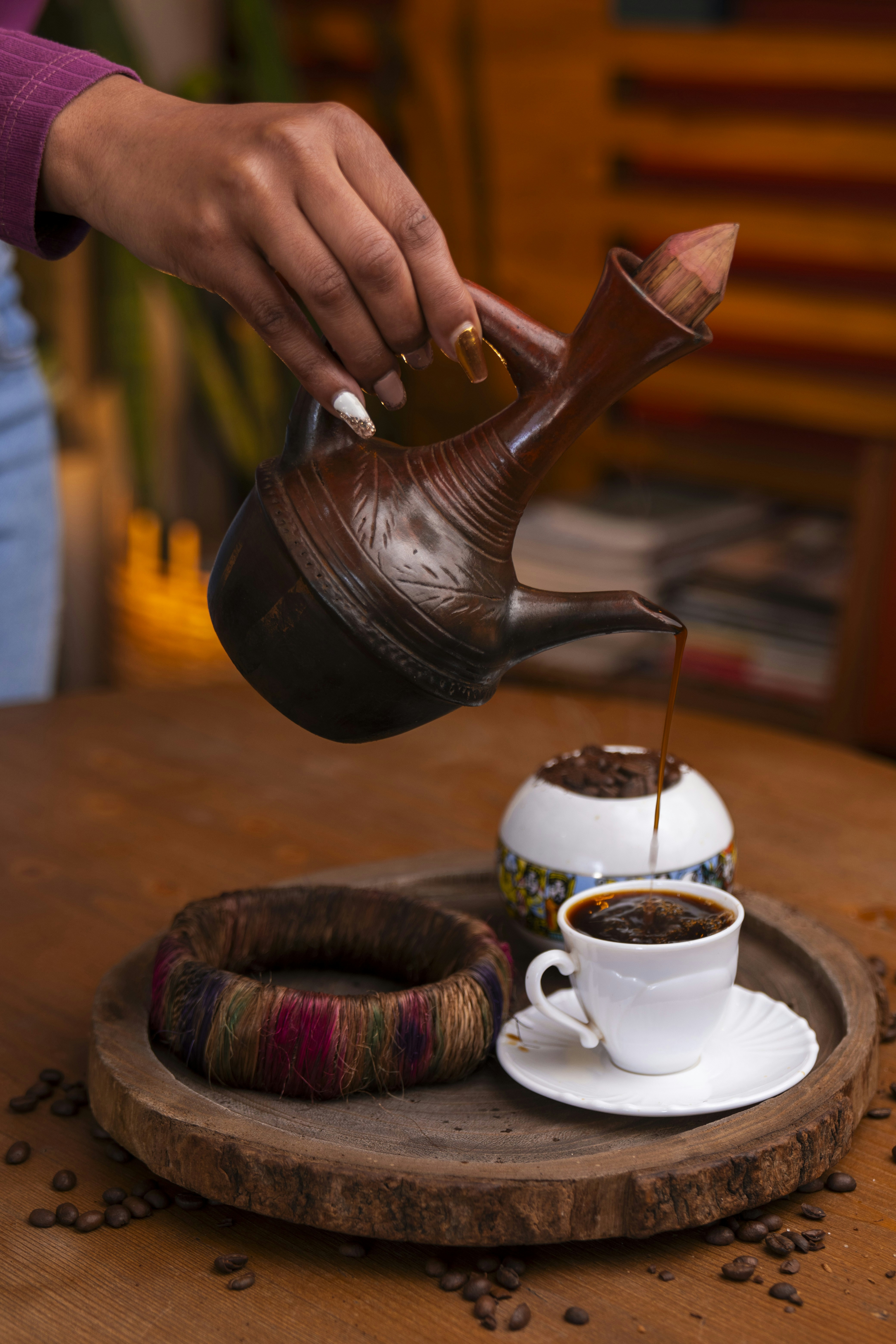 Pouring coffee from a traditional Ethiopian jebena into a sinii cup