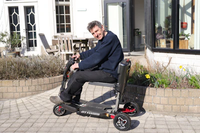 Man riding a mobility scooter outdoors