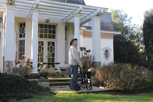 Elderly person with walker in front of a house